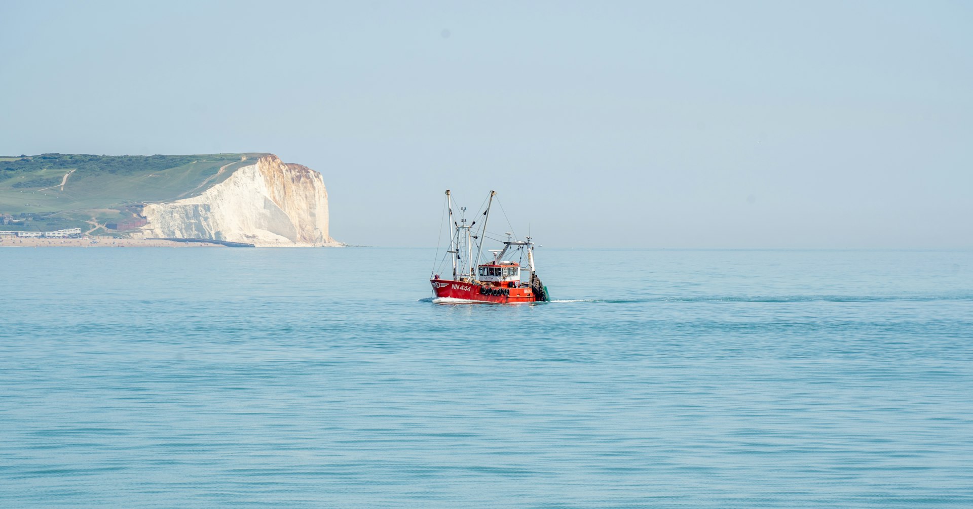 A red boat in the middle of the ocean