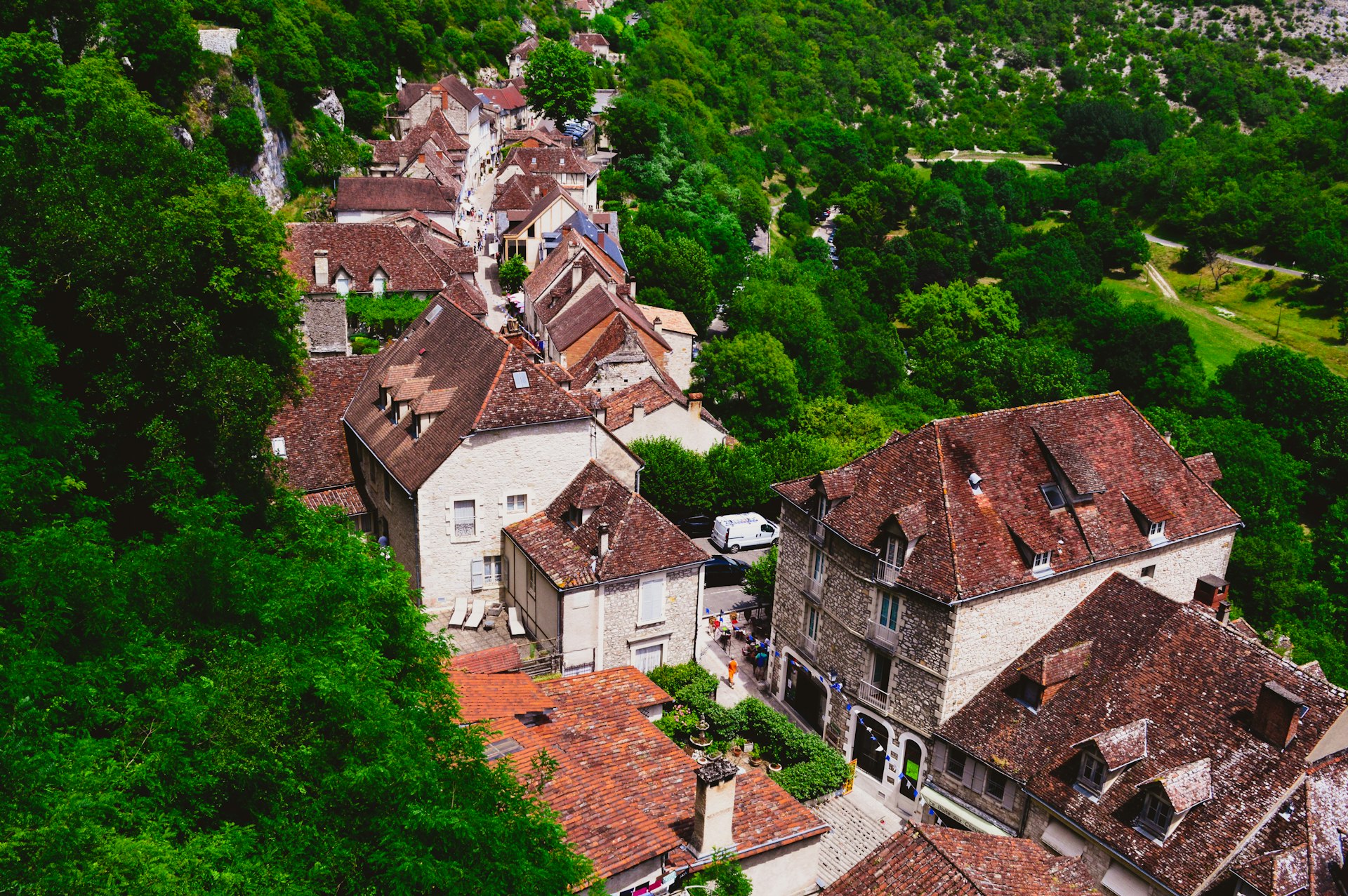 brown and white concrete houses surrounded by green trees during daytime