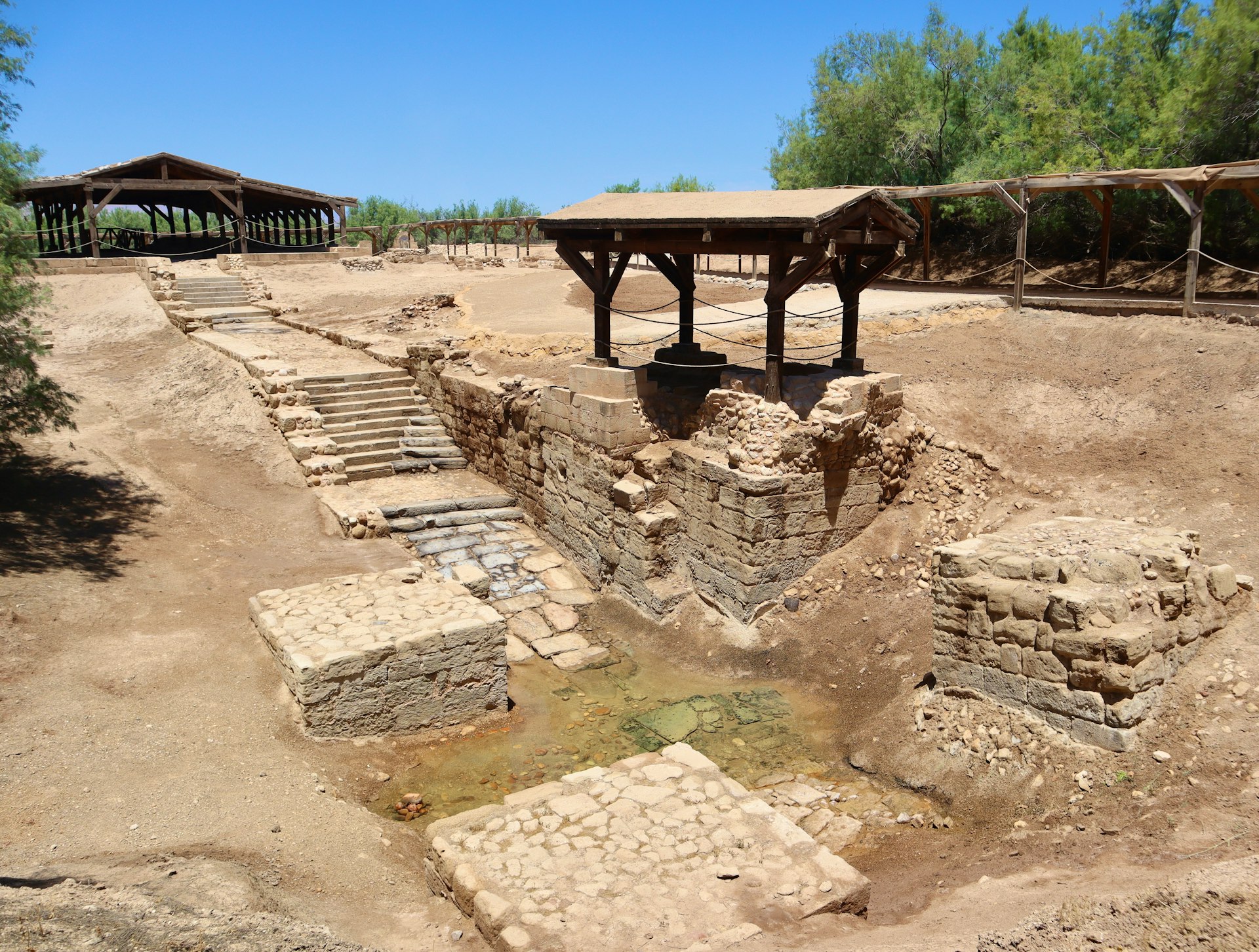 A very old structure in the middle of a dirt field