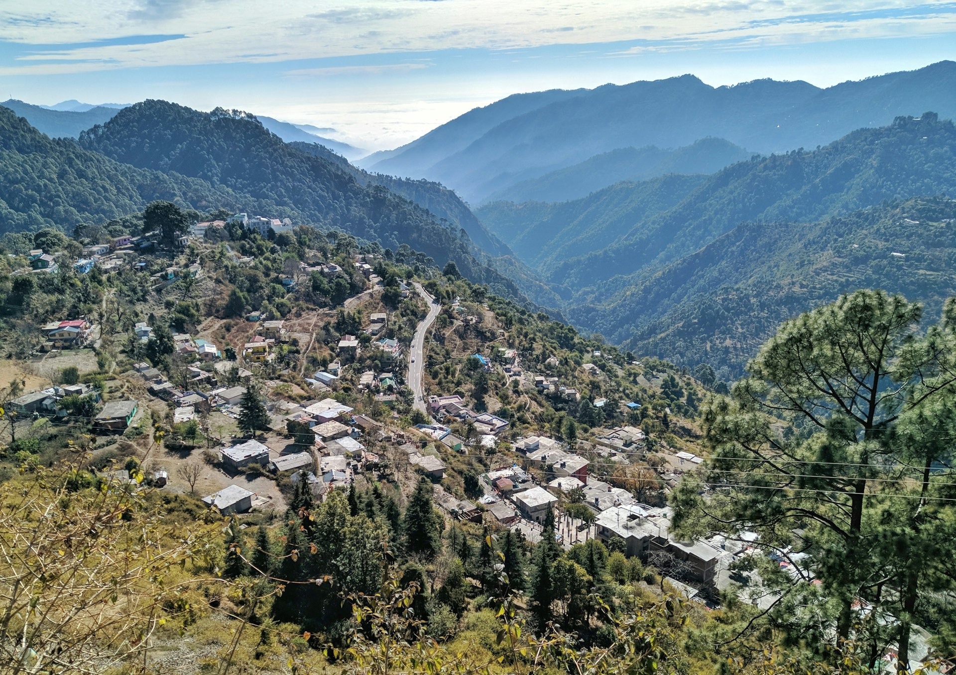 aerial view of city near green mountains during daytime