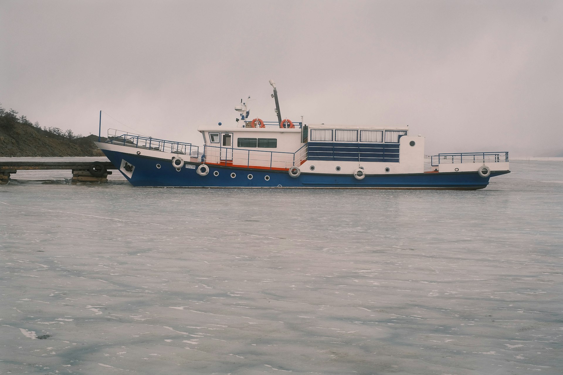 a blue and white boat sitting on top of a body of water