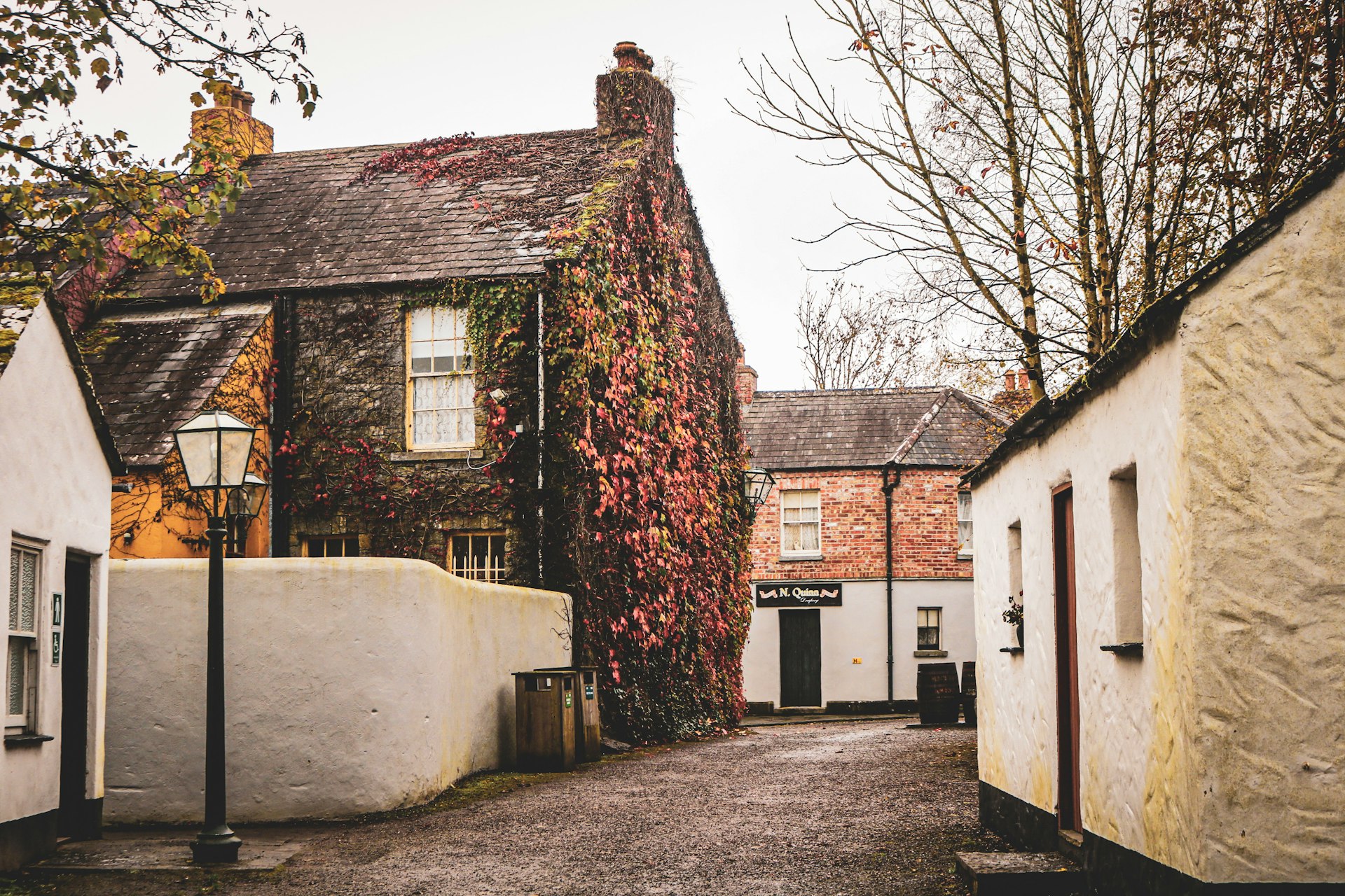 a narrow street with houses and a lamp post