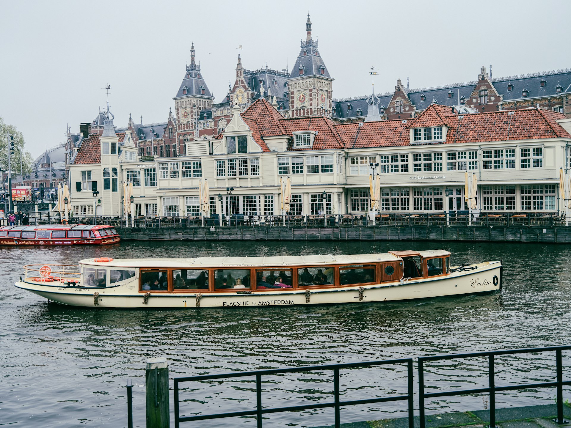 a long boat traveling down a river next to buildings