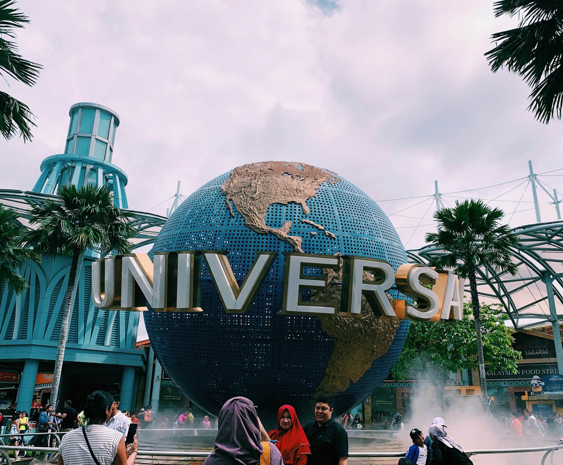 people taking photos in front of Universal globe