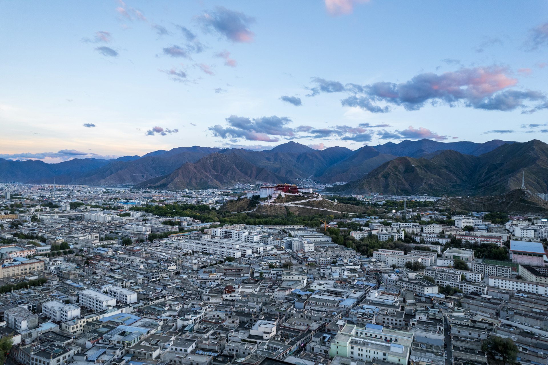 an aerial view of a city with mountains in the background