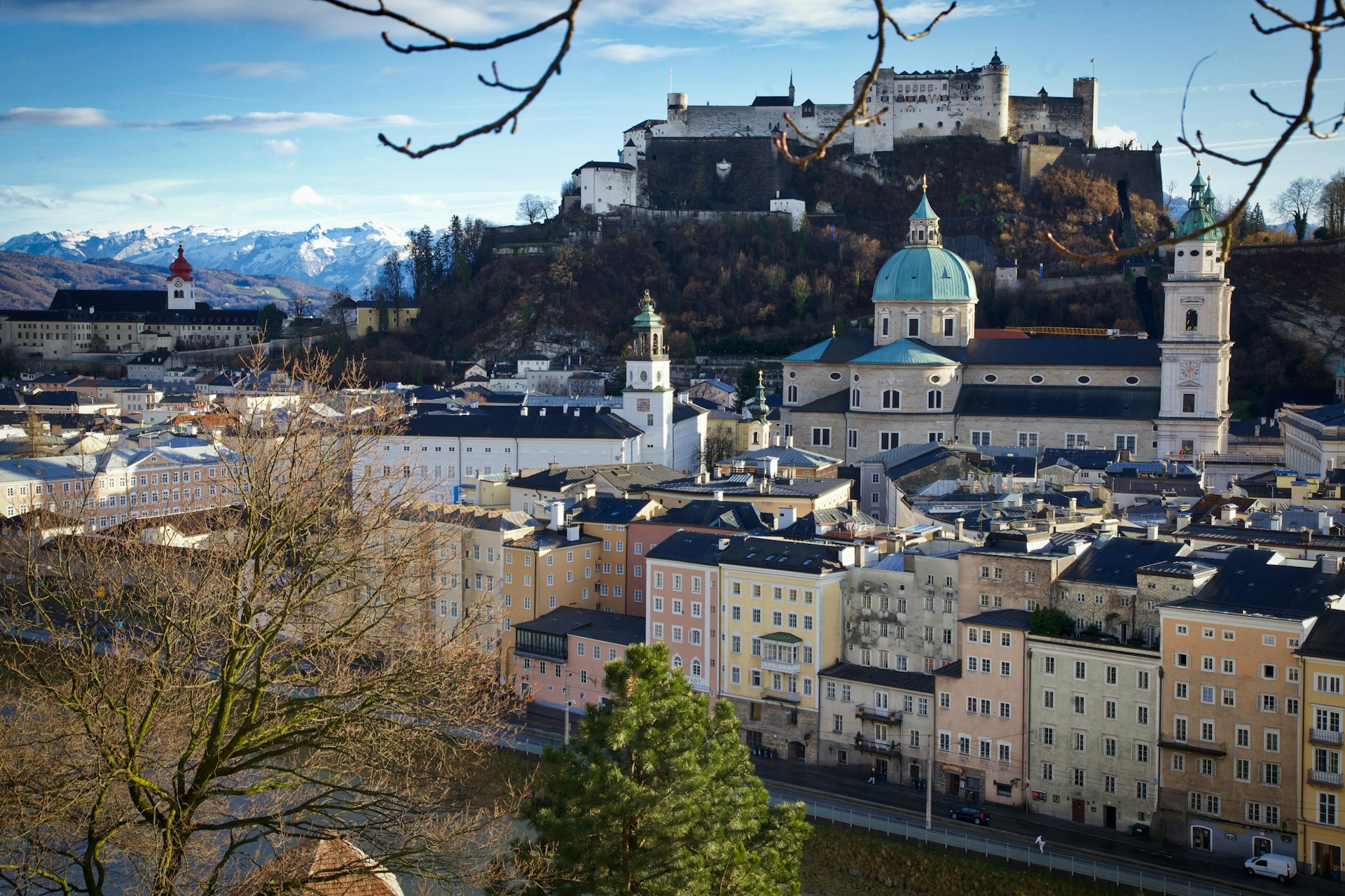 white and brown concrete buildings near green trees under blue sky during daytime