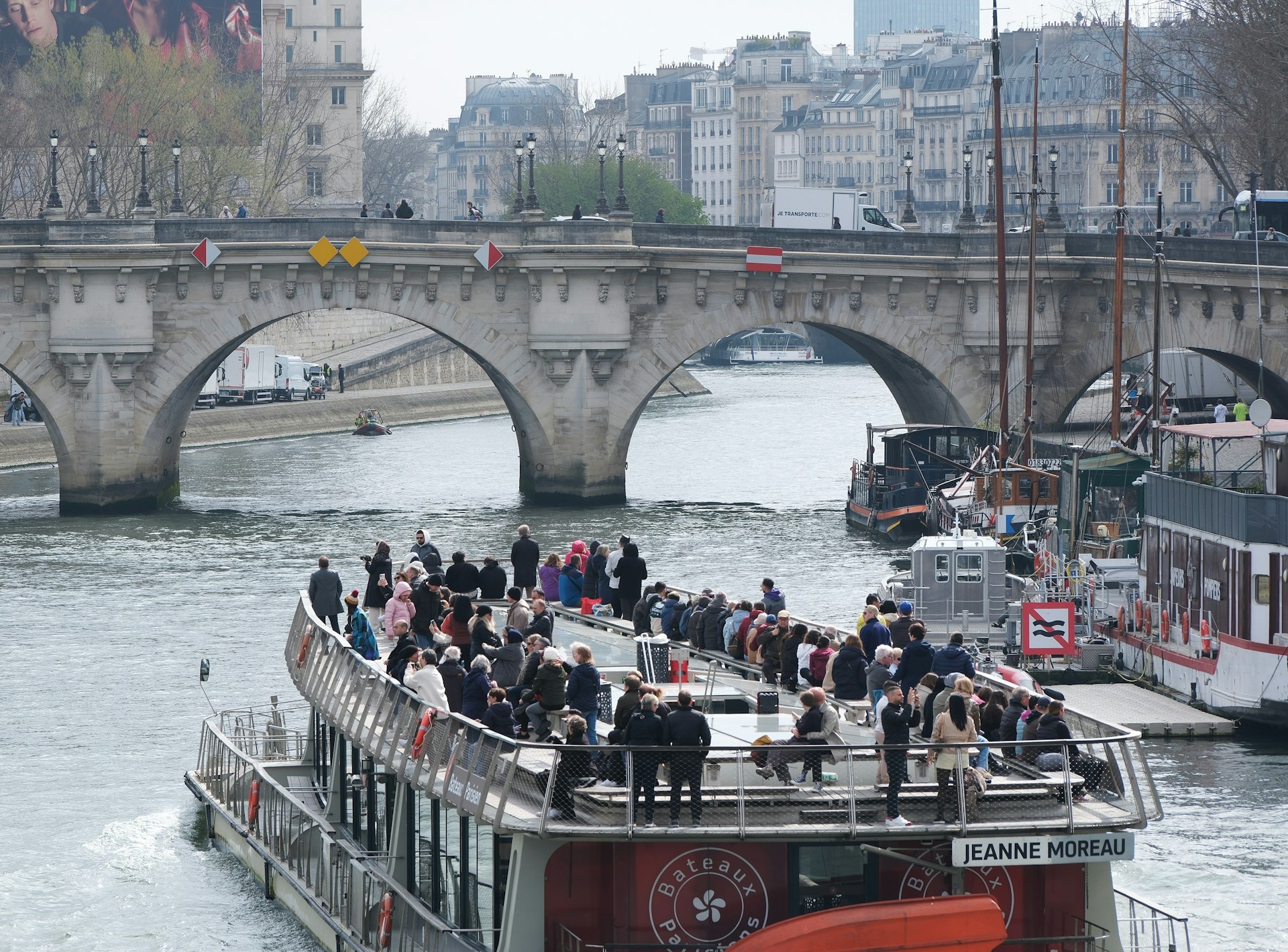 A boat filled with tourists sails on a river.