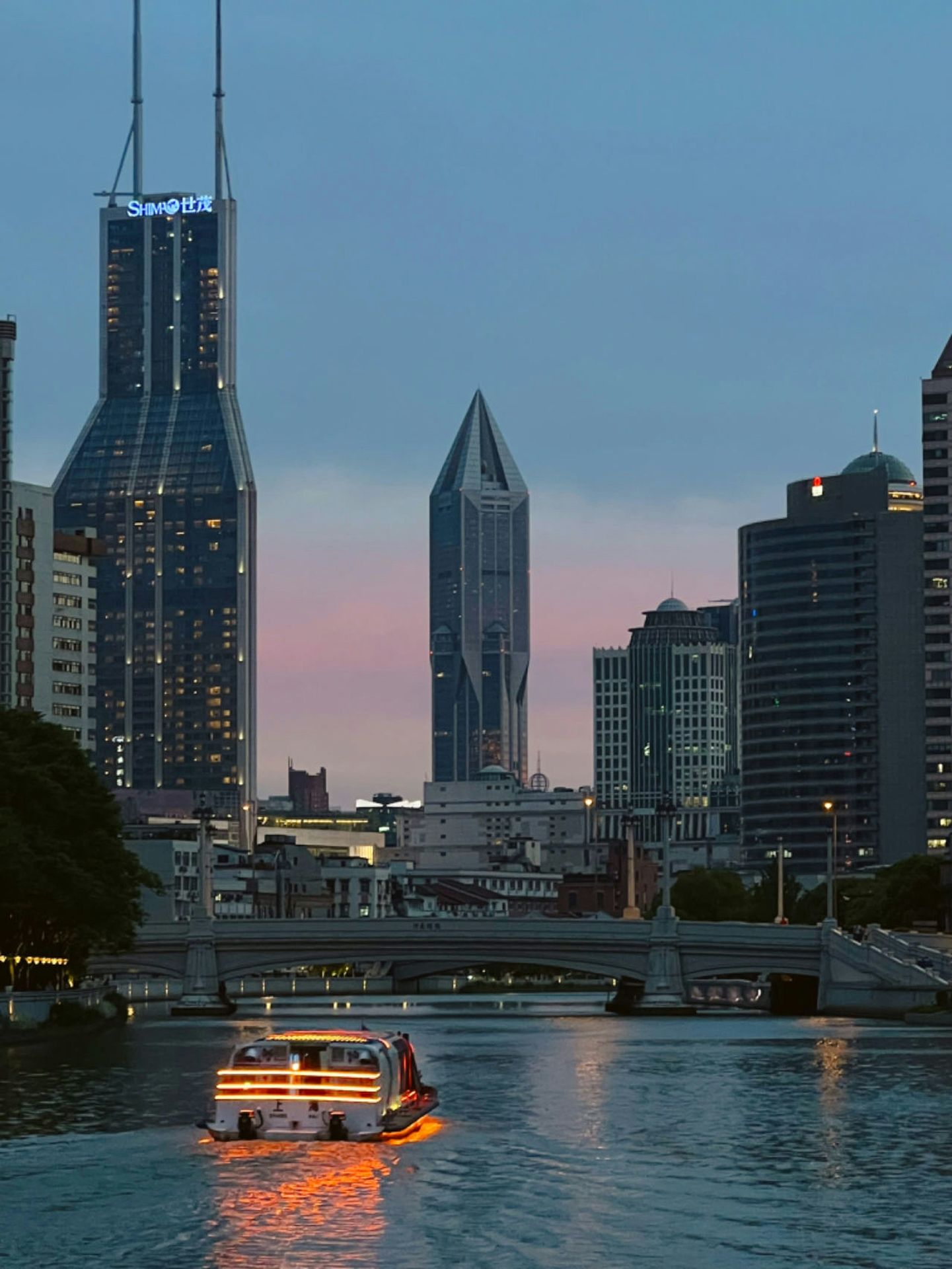 a boat traveling down a river next to tall buildings