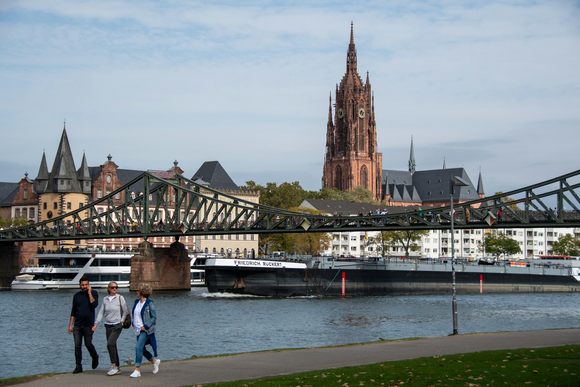 a group of people standing on a sidewalk next to a river