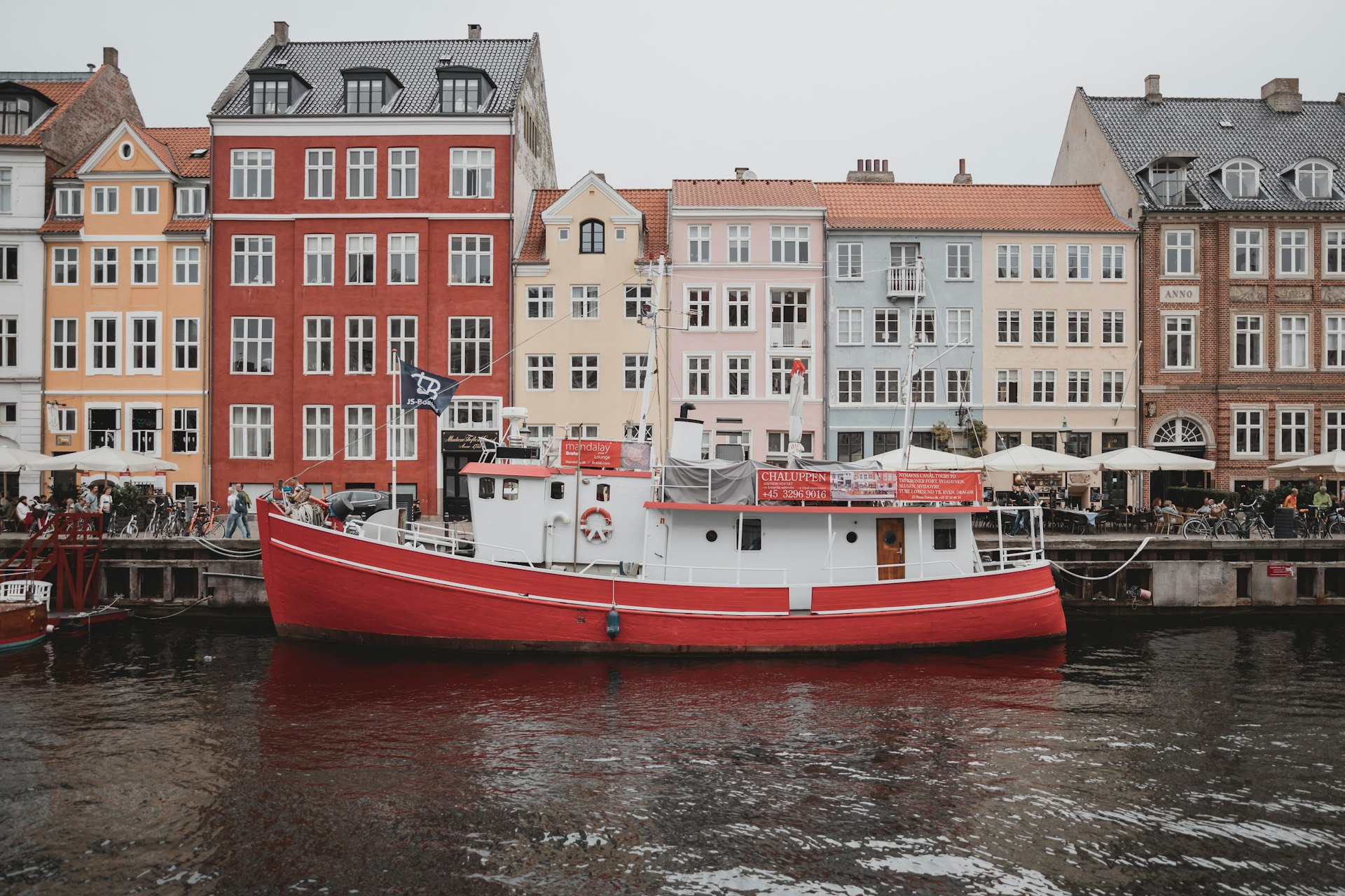 white and orange boat on water near buildings