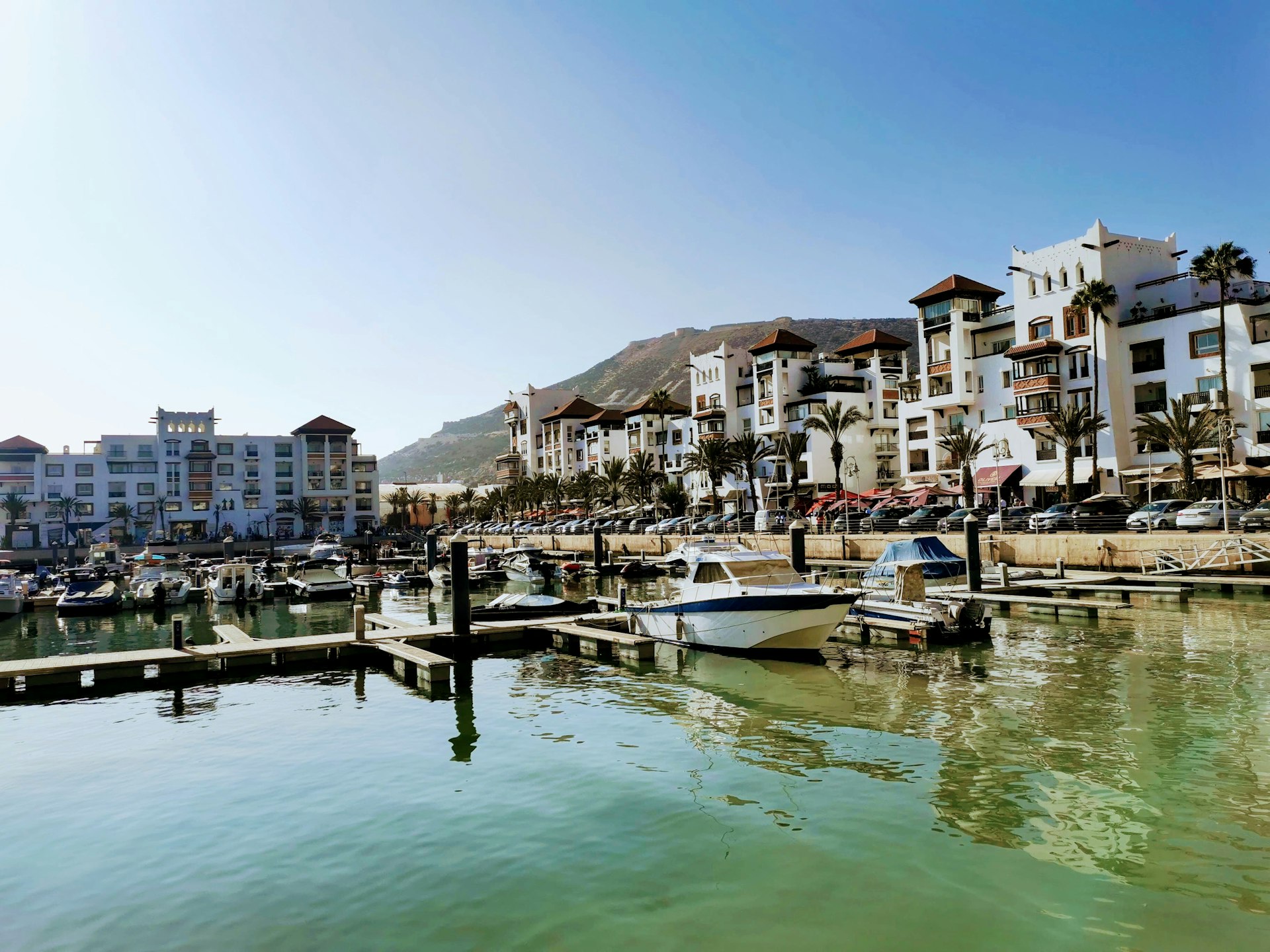 white boat on dock near buildings during daytime