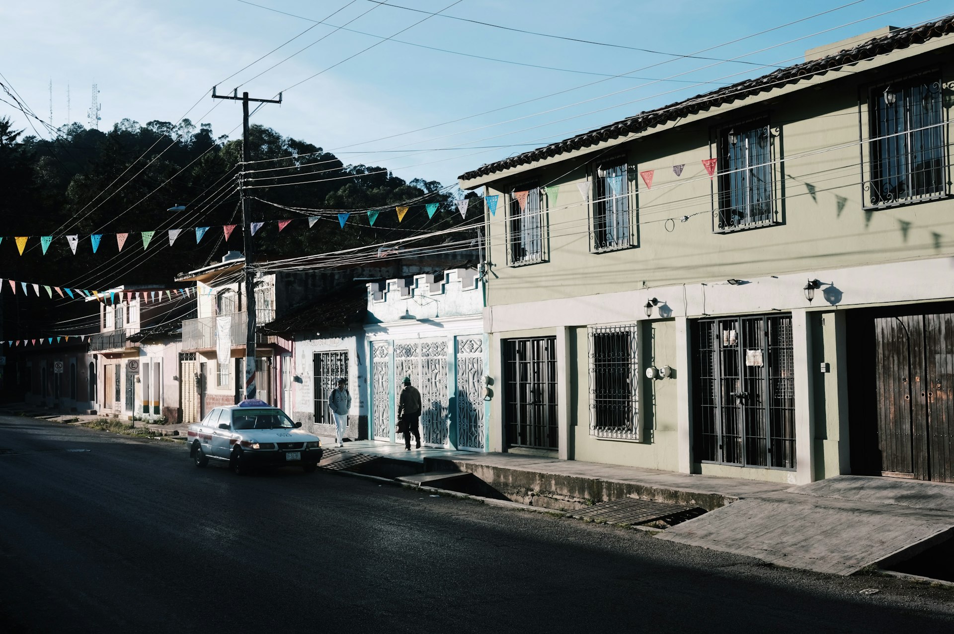 a car driving down a street next to a tall building