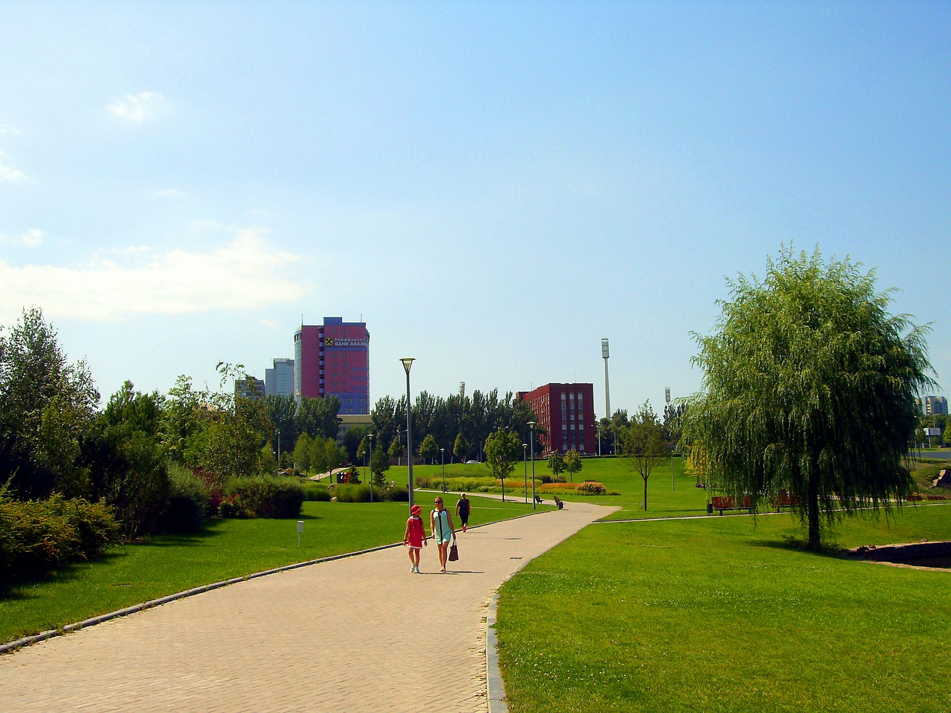 Two people walking down a path in a park