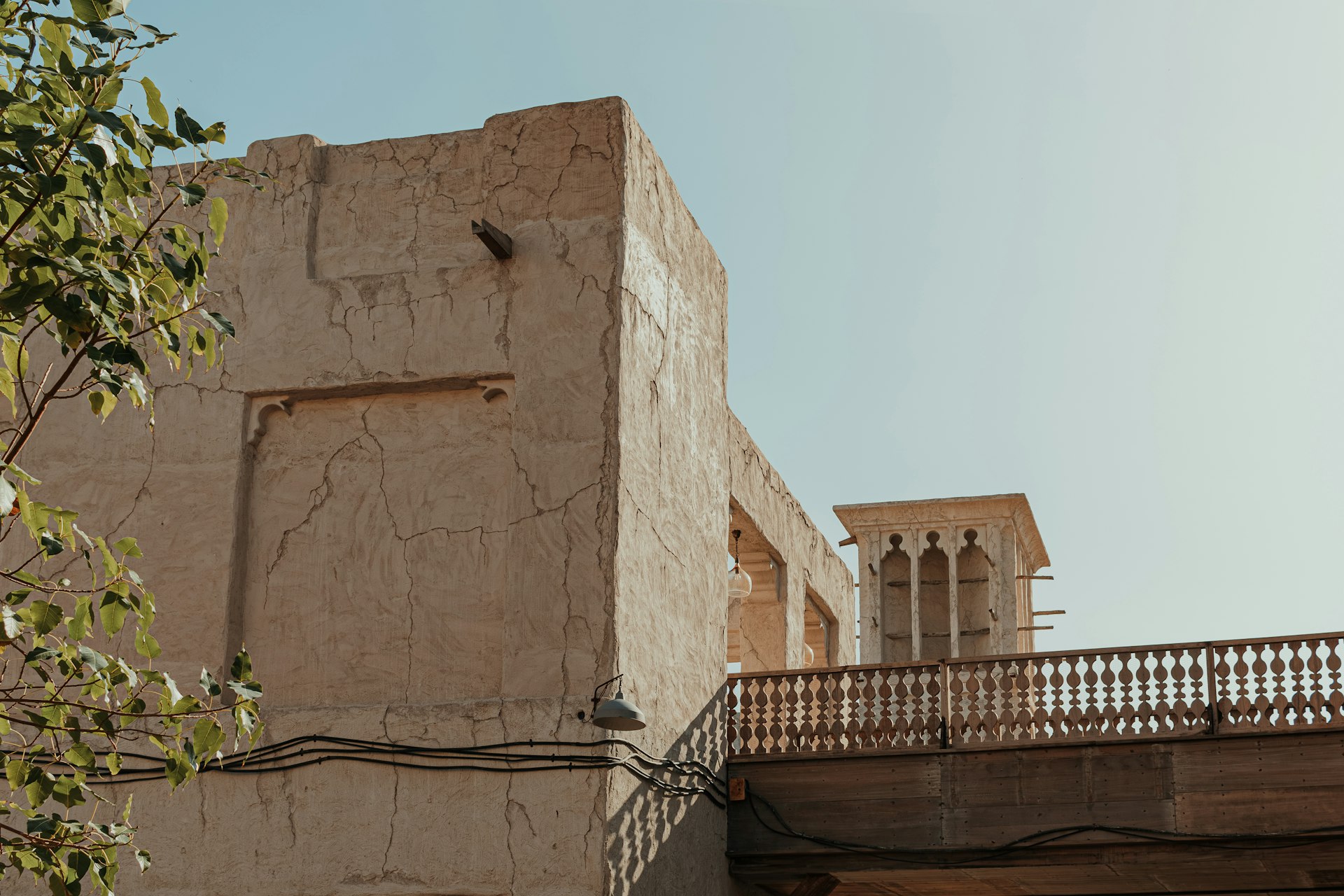 A tall building with a balcony and a clock on it