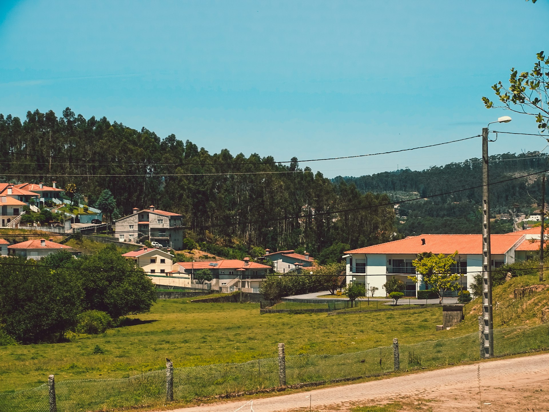 a green field with houses in the background