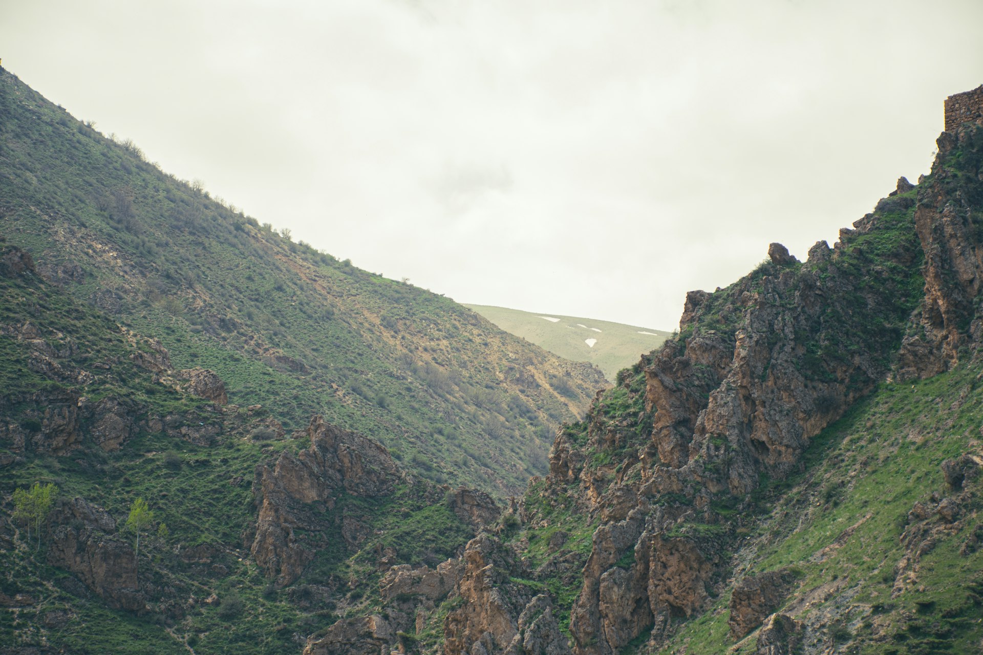 Rugged mountains rise under a cloudy sky.