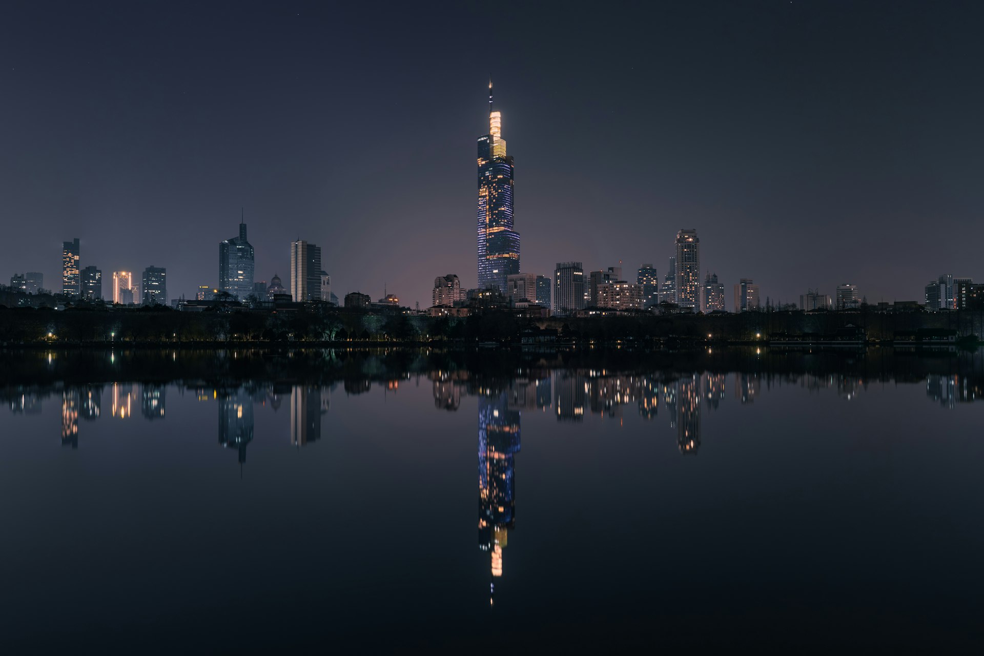 Nighttime skyline reflected in water.