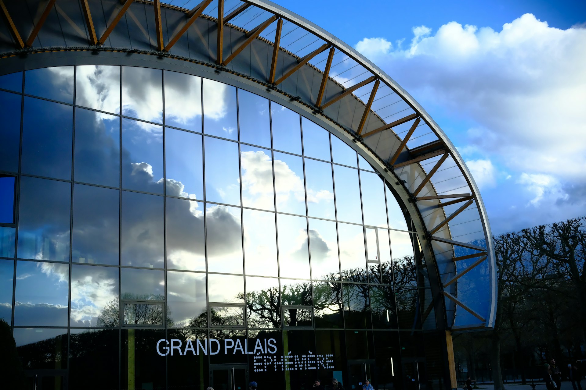a large glass building with a sky in the background