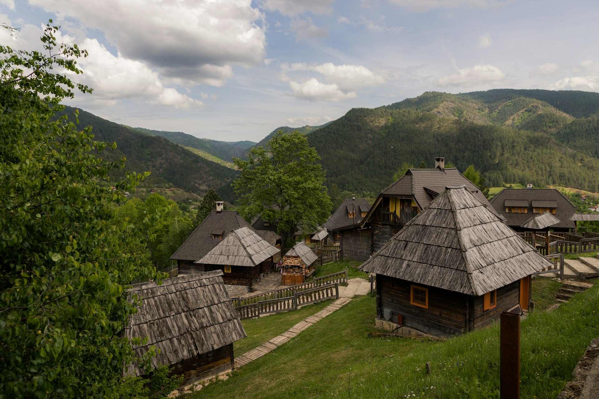 a group of houses with thatched roofs in the mountains