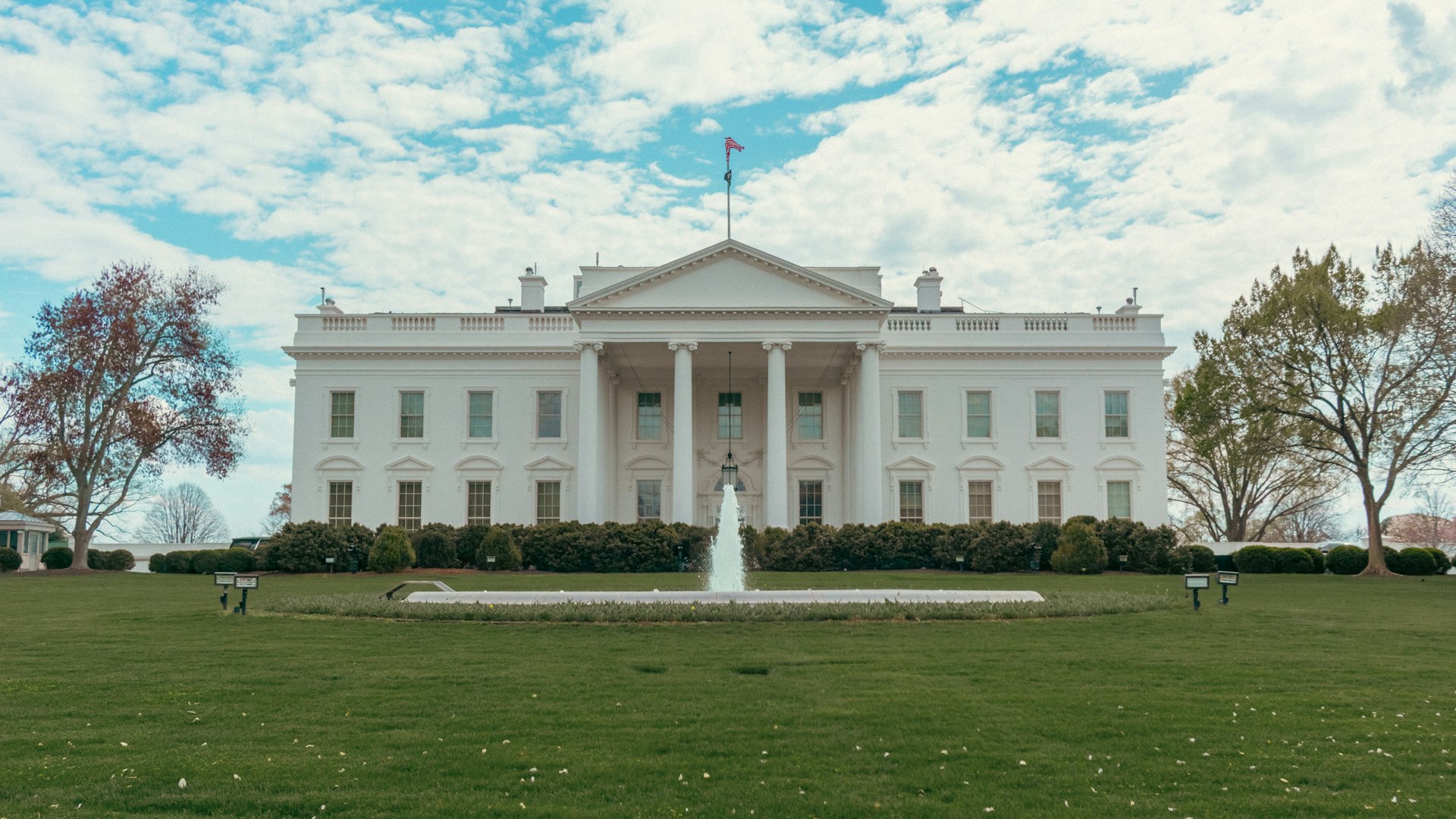 The white house stands under a bright sky.