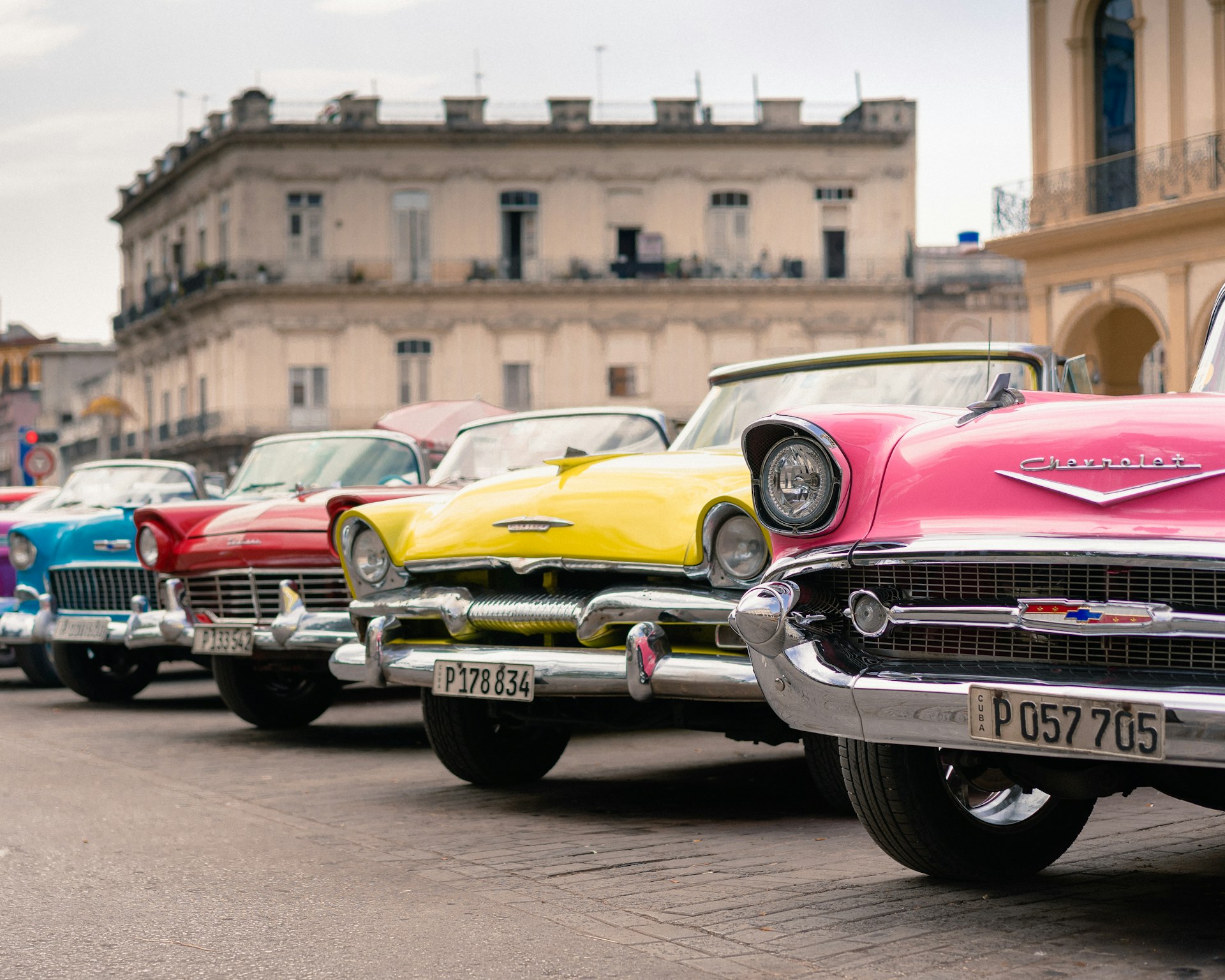 assorted-colored antique cars parking near road