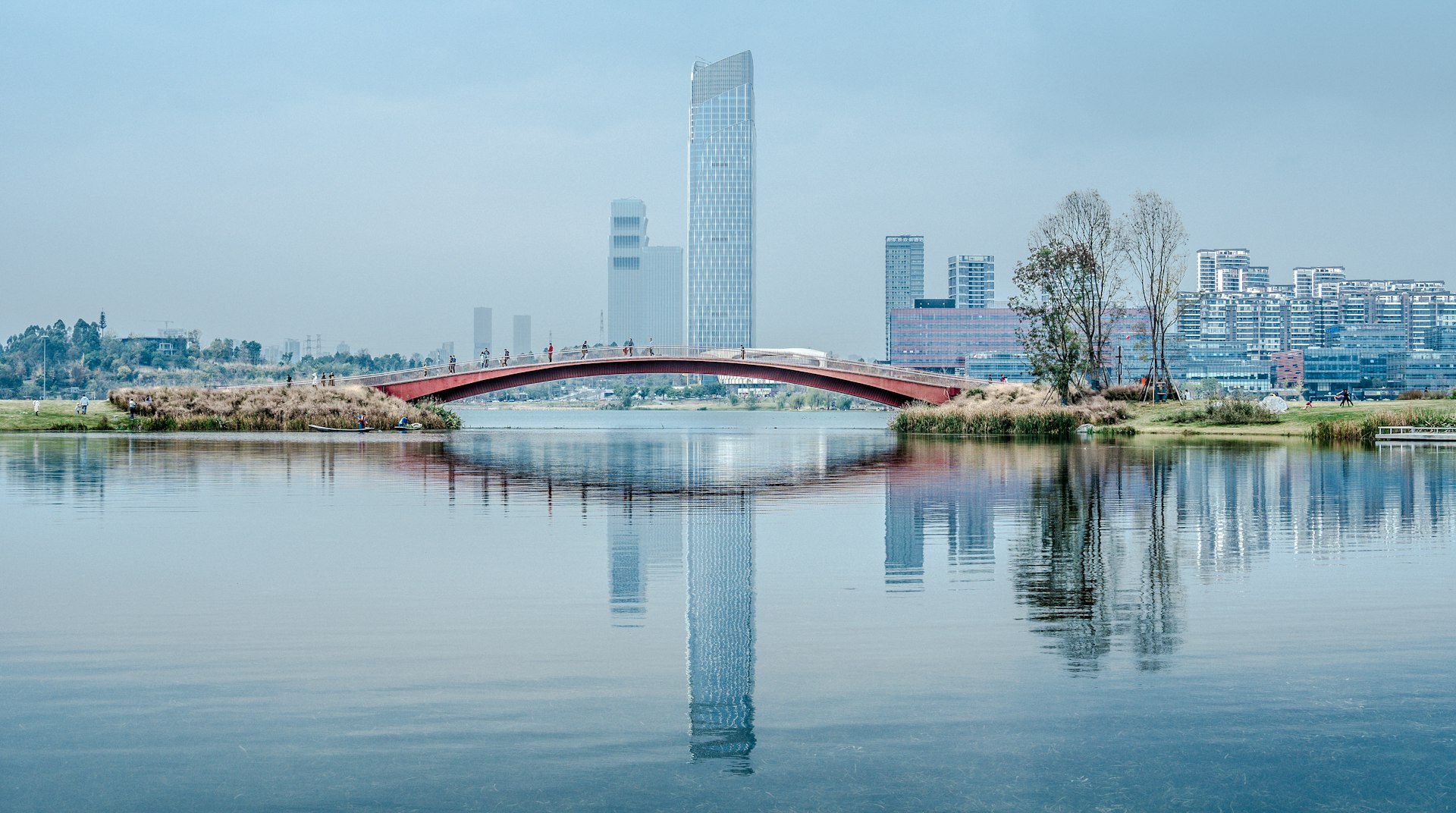 a bridge over a body of water with a city in the background