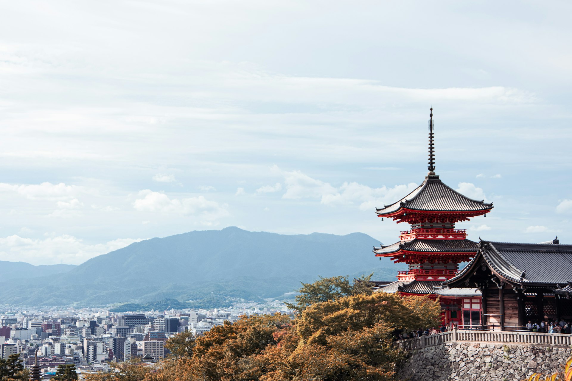 a tall red building sitting on top of a lush green hillside