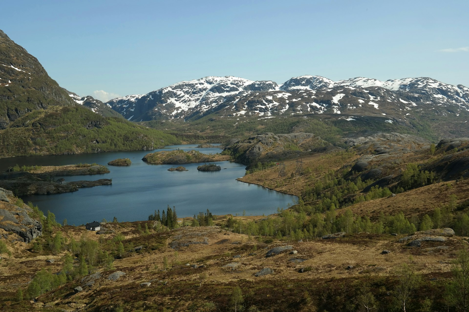 A lake surrounded by mountains with snow on the tops