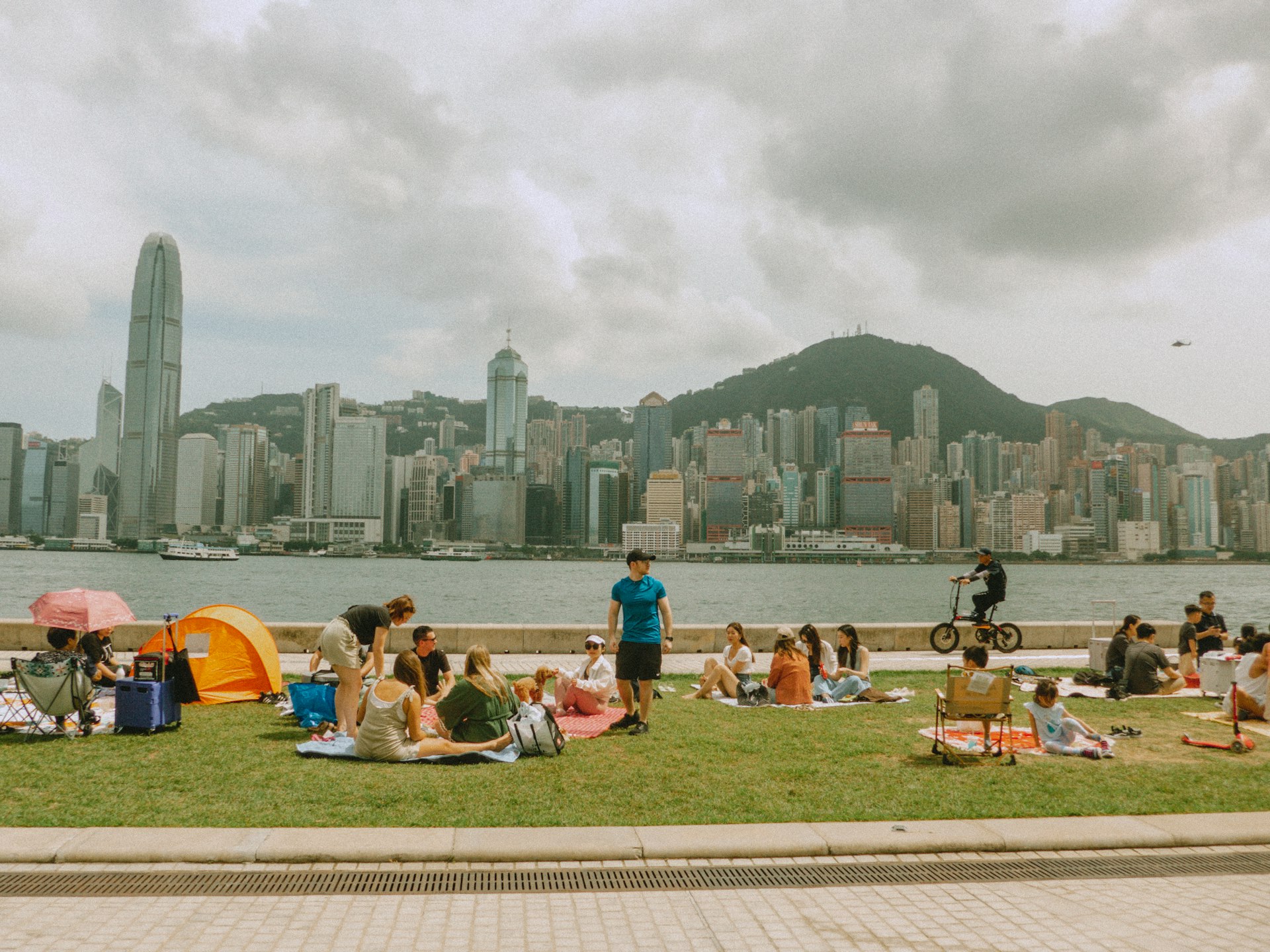 A group of people sitting on top of a lush green field