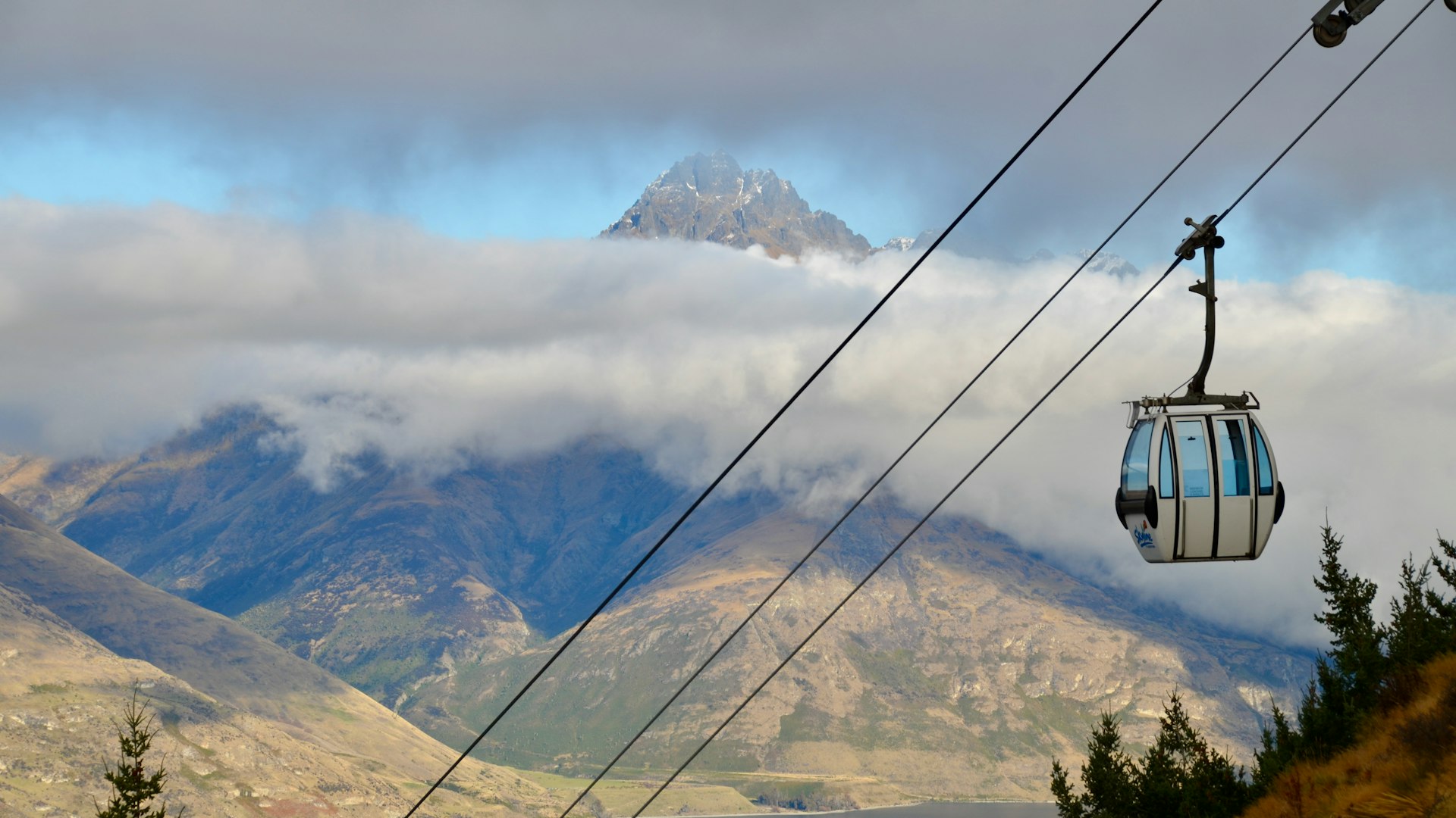 black cable wire over green trees and mountains during daytime