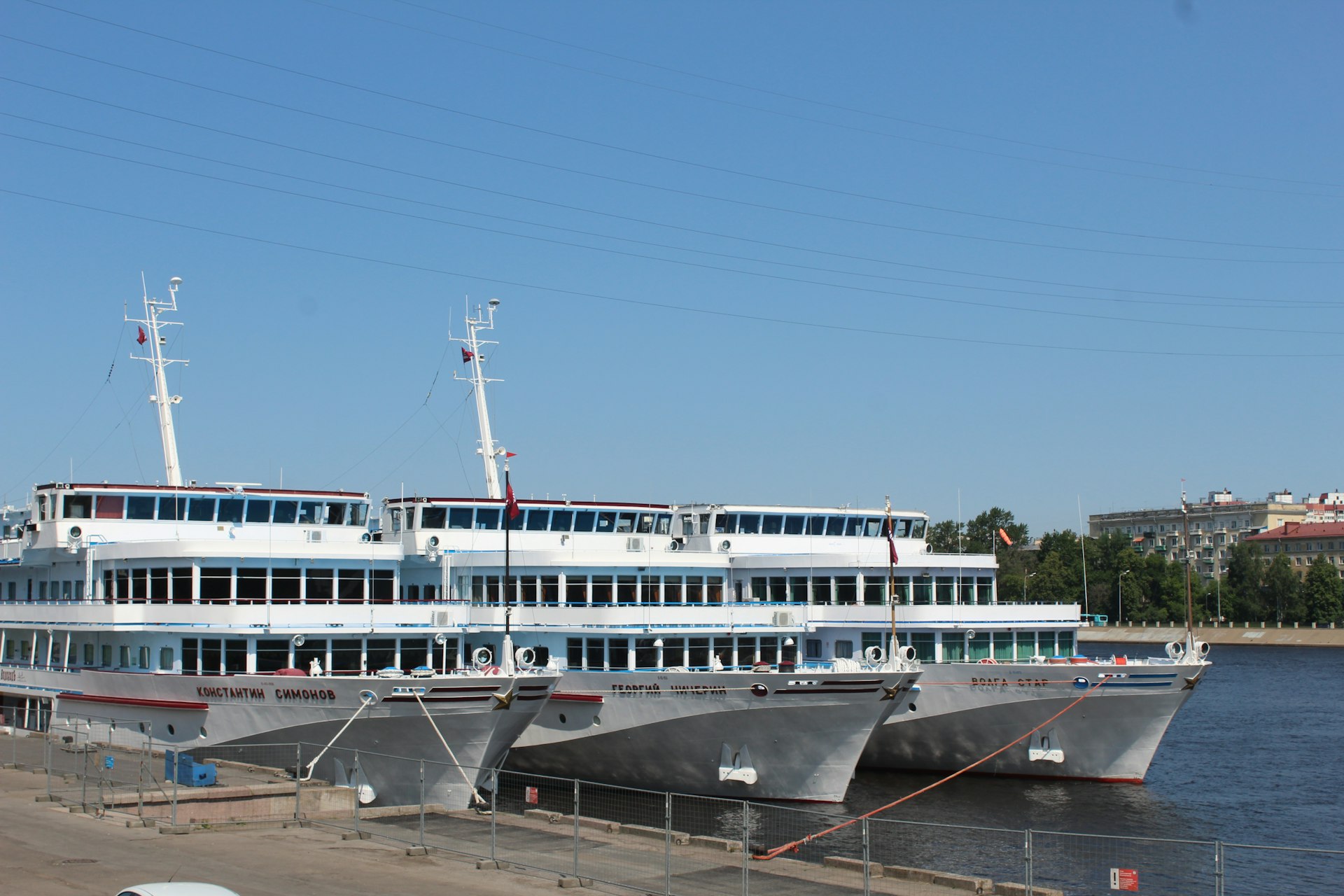 Three cruise ships are docked on the water.