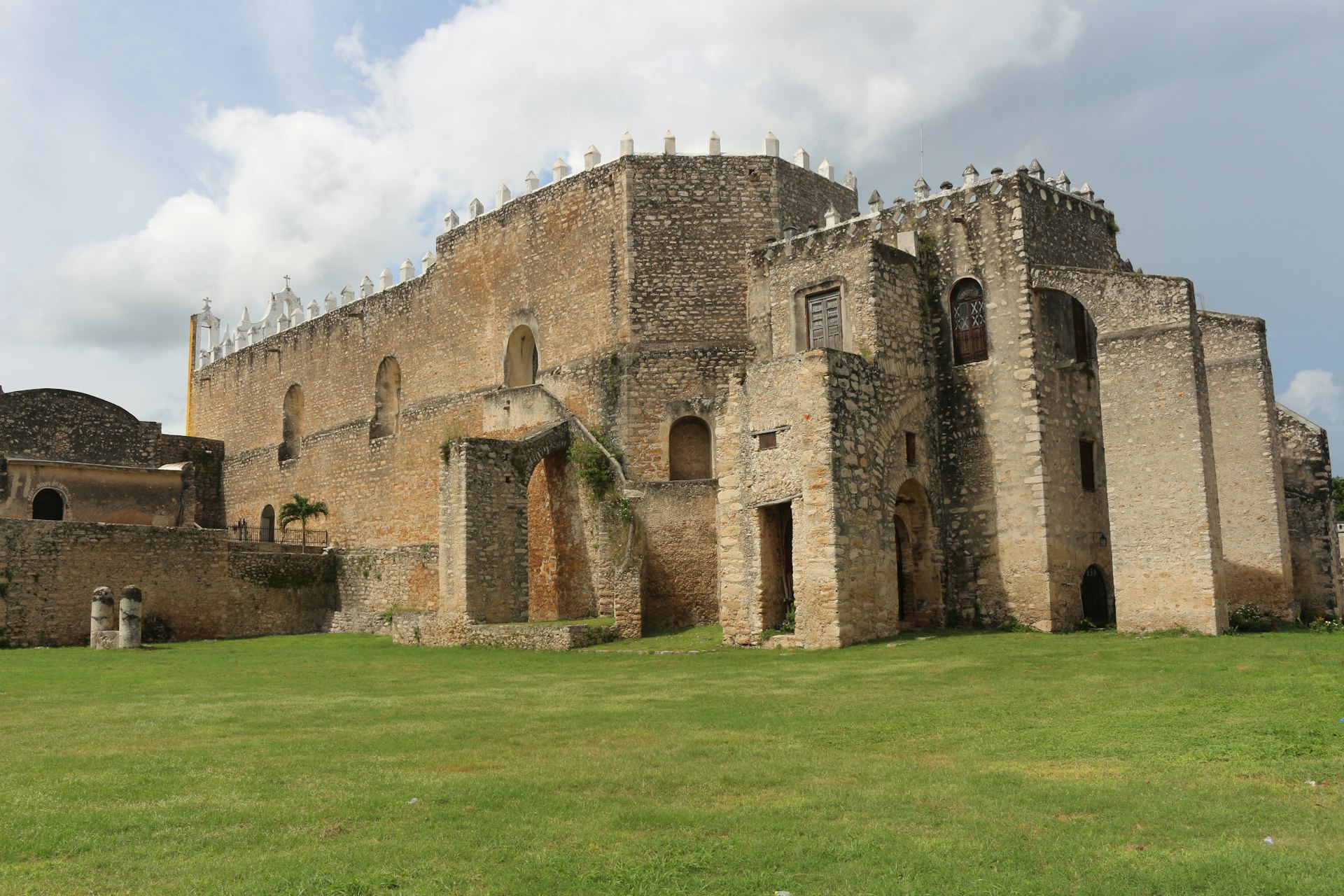 a stone building with a grass field