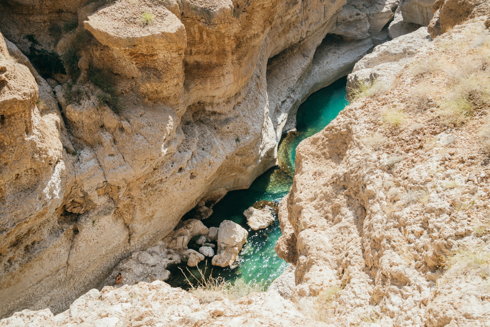 A blue canyon with bright water and rock walls.