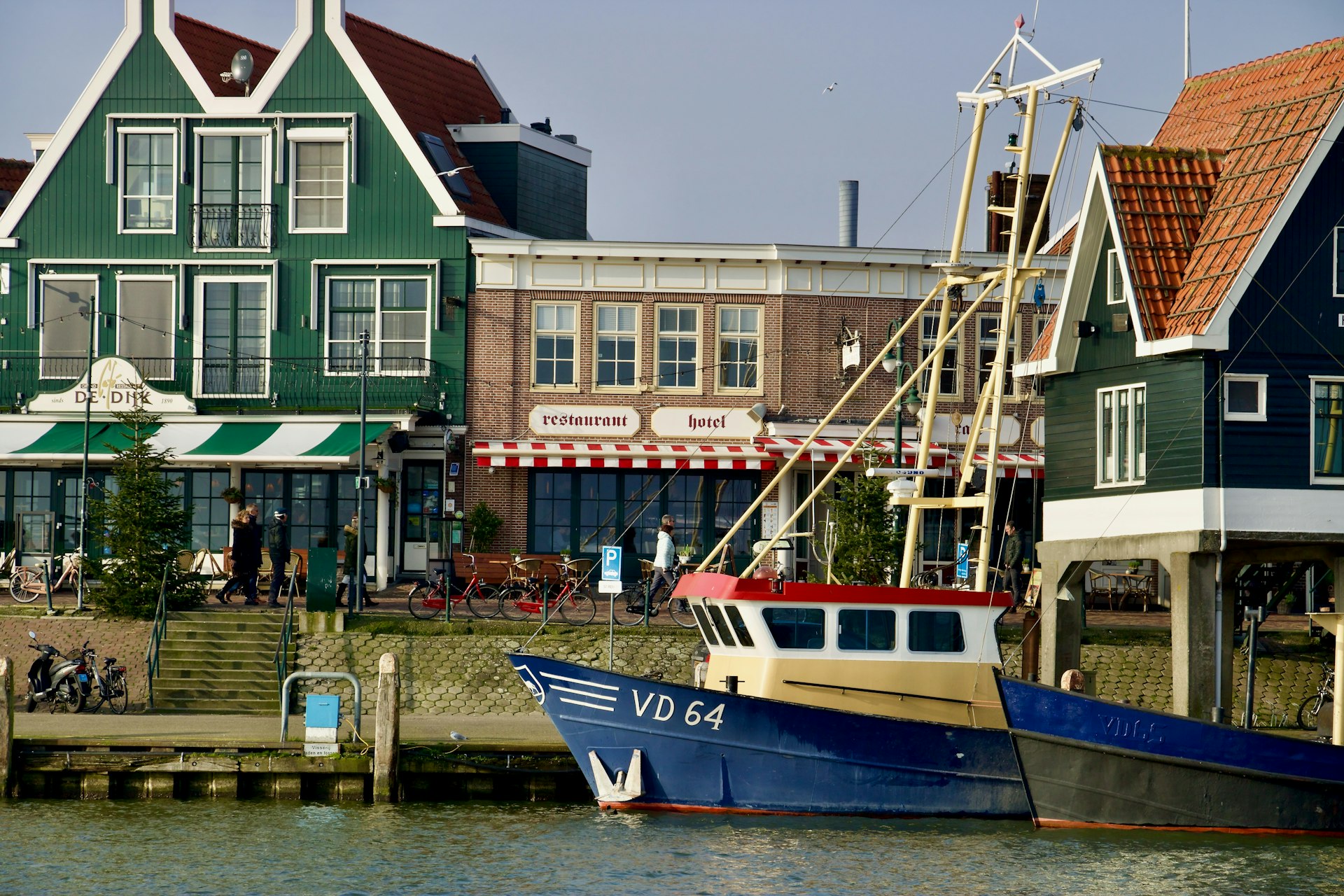 blue and white boat on water near brown concrete building during daytime