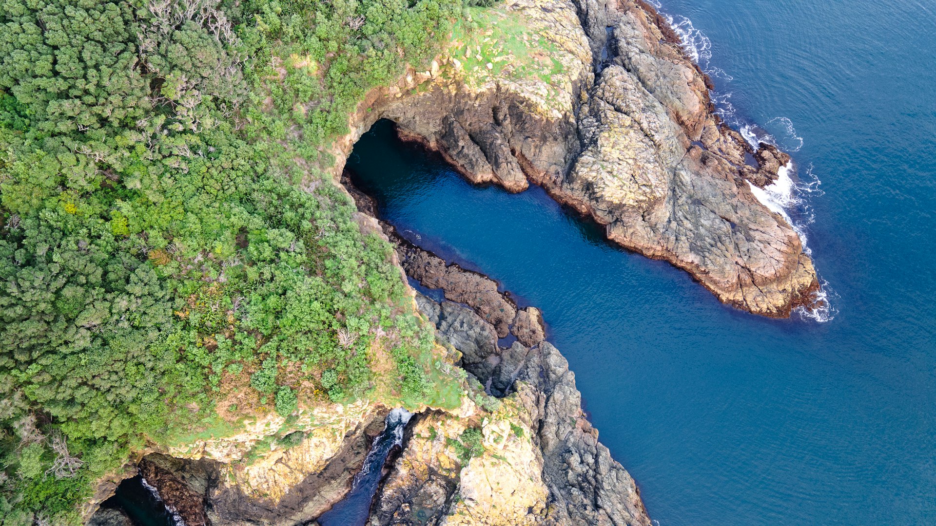 a rocky cliff with a body of water below