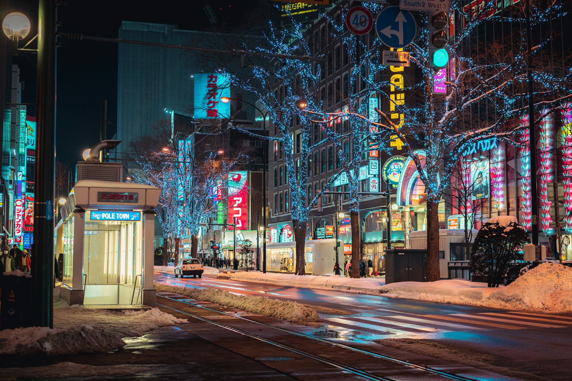 a city street is lit up with christmas lights