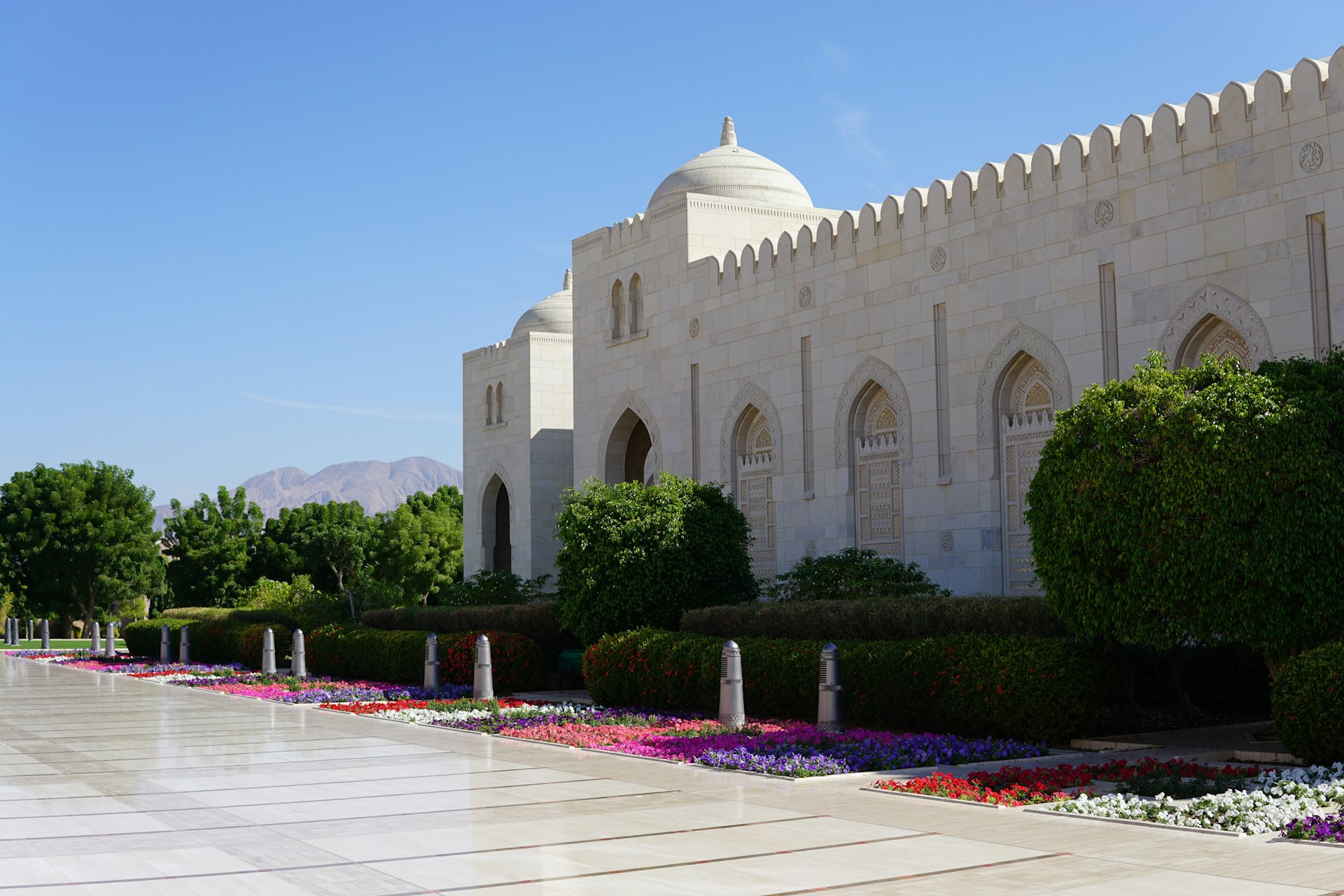 A white building with a large garden in front of it