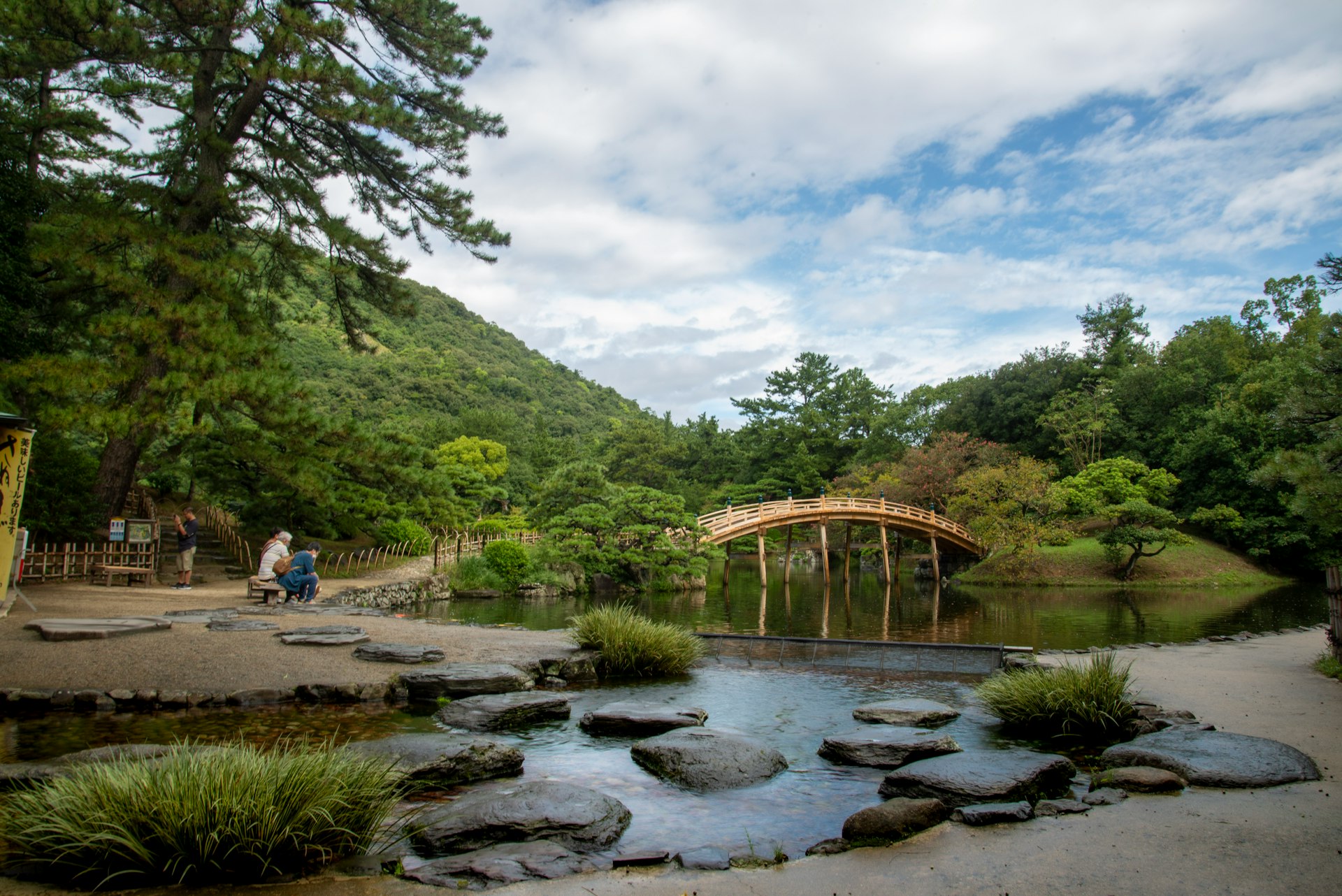 a couple of people walking across a bridge over a river