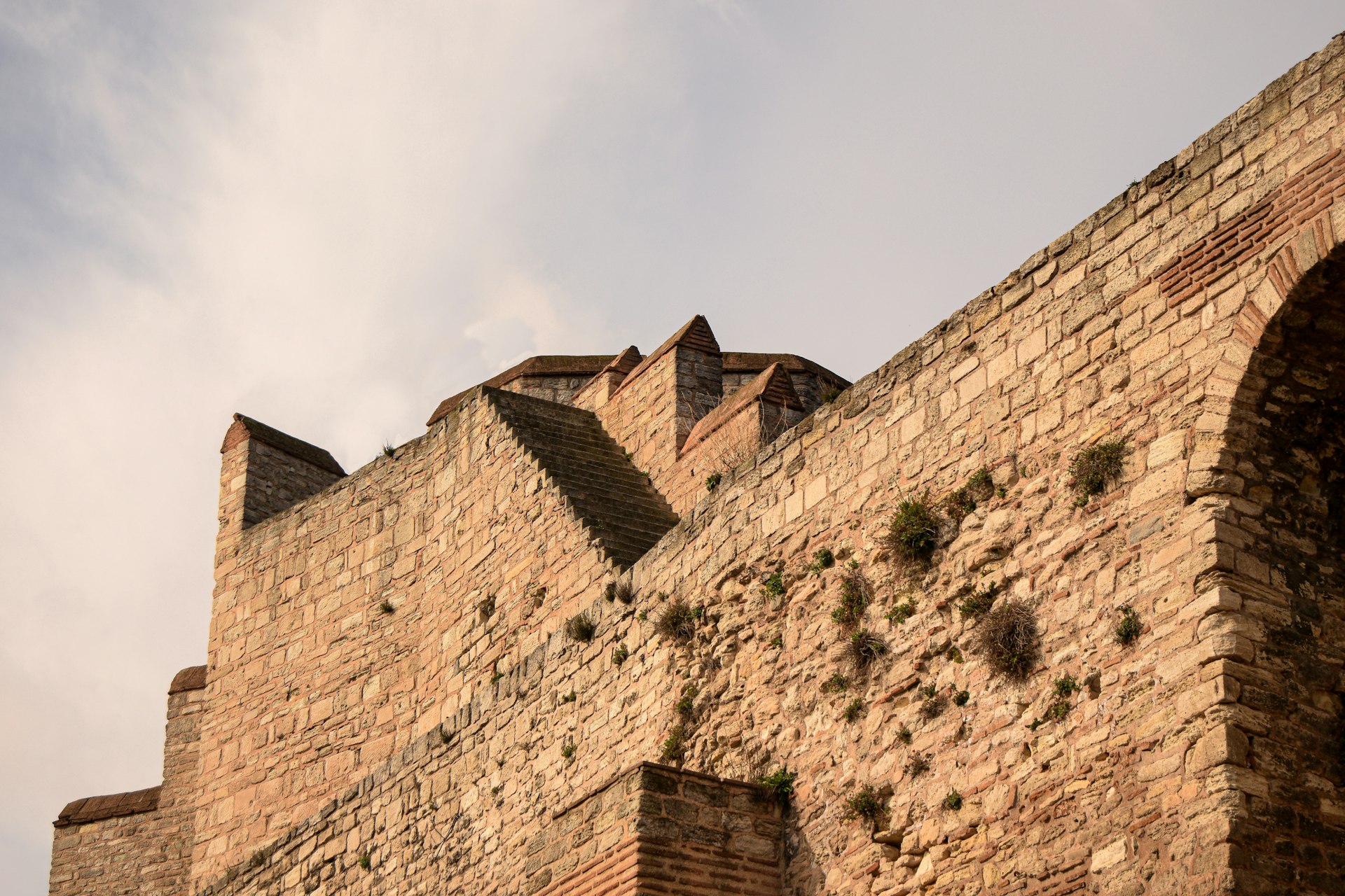 A tall brick building with a clock on it's side