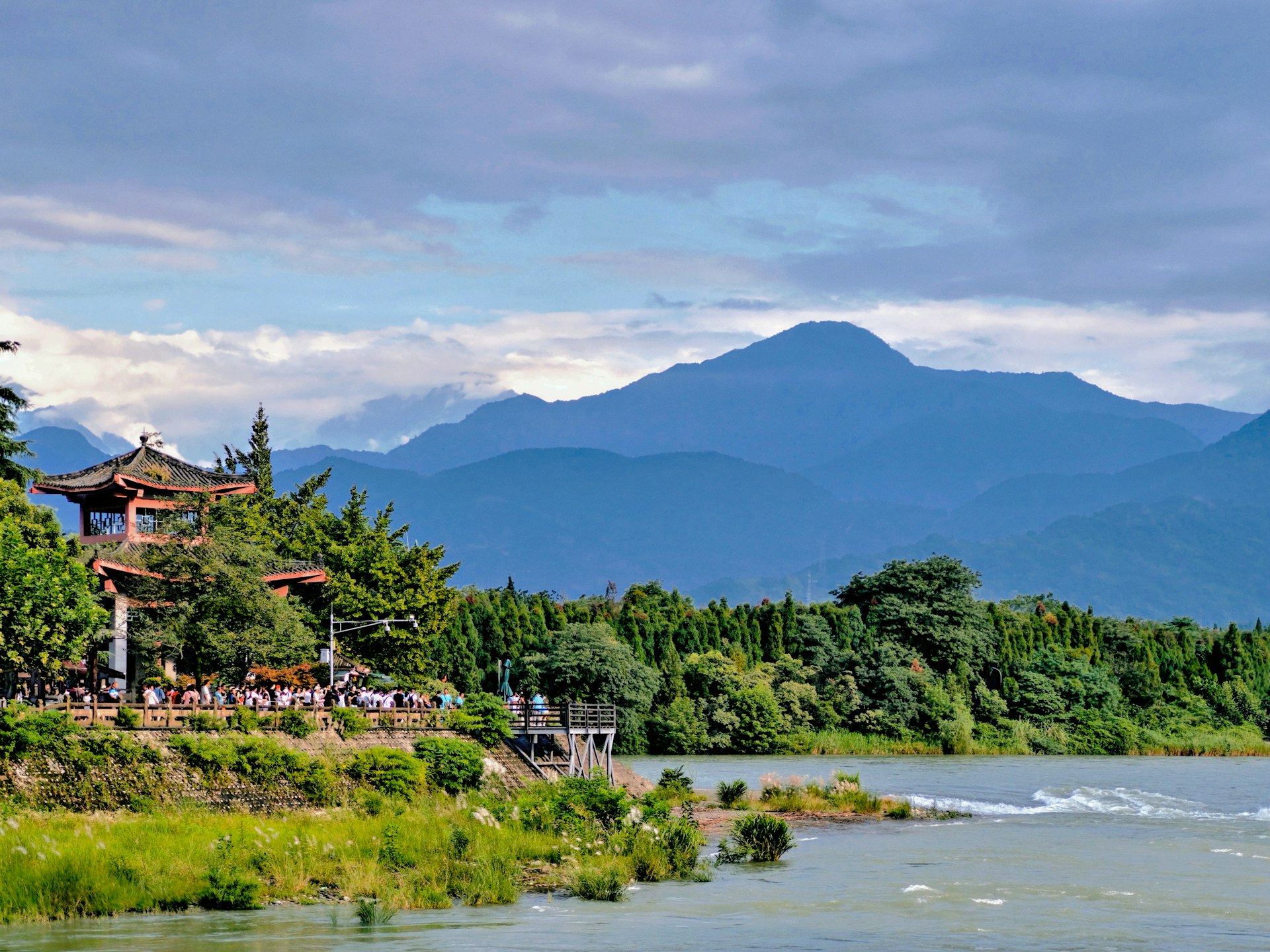 a scenic view of a river with a pagoda in the background