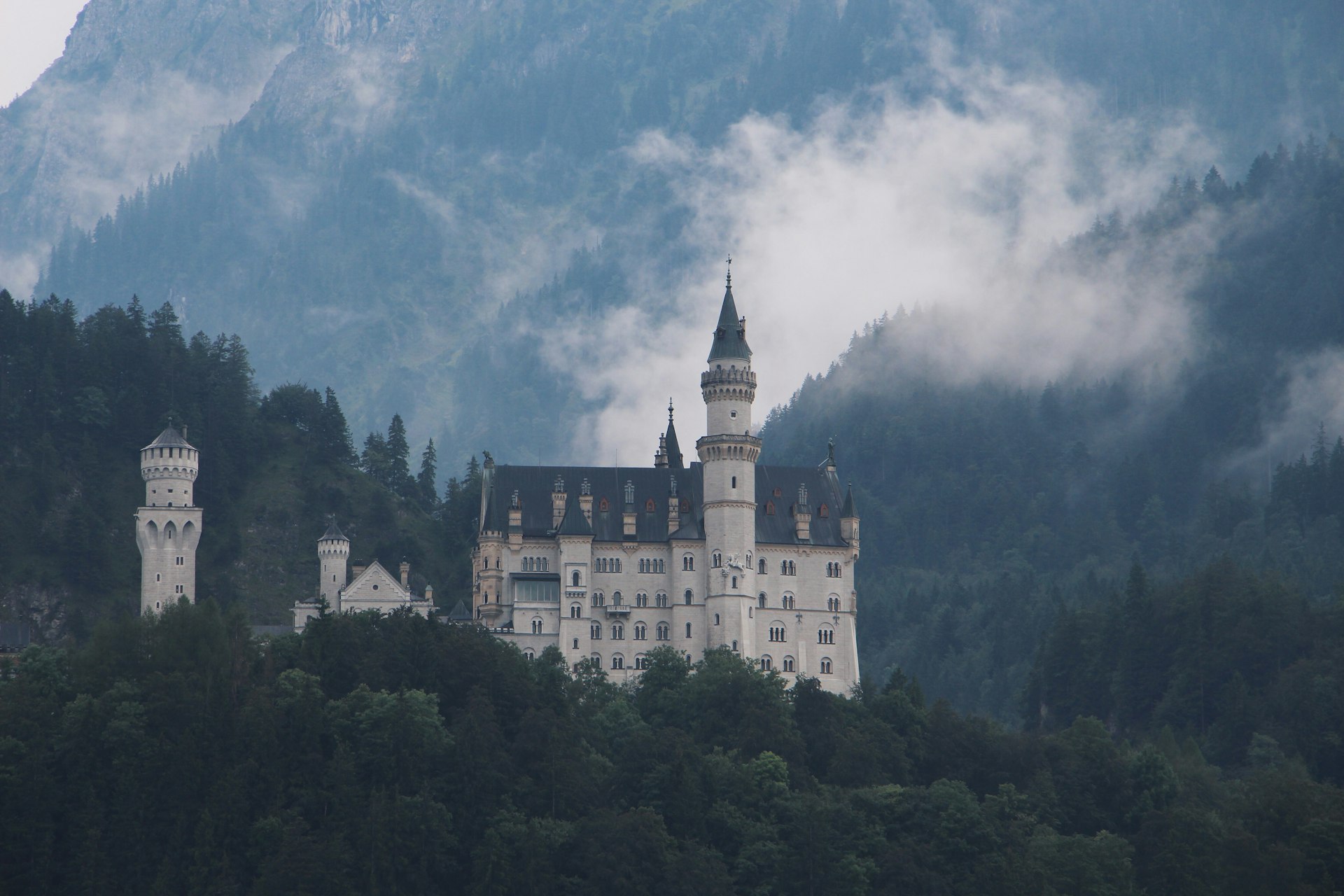 white and black castle on top of green mountain