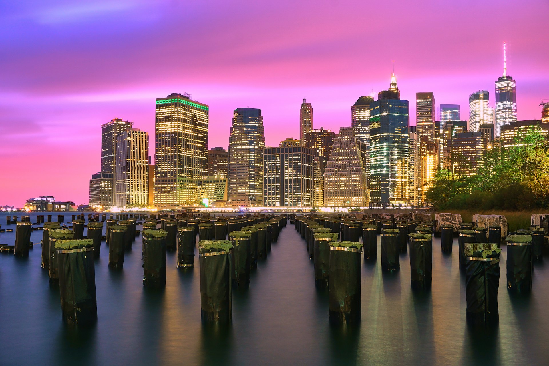 lighted high-rise buildings under purple sky