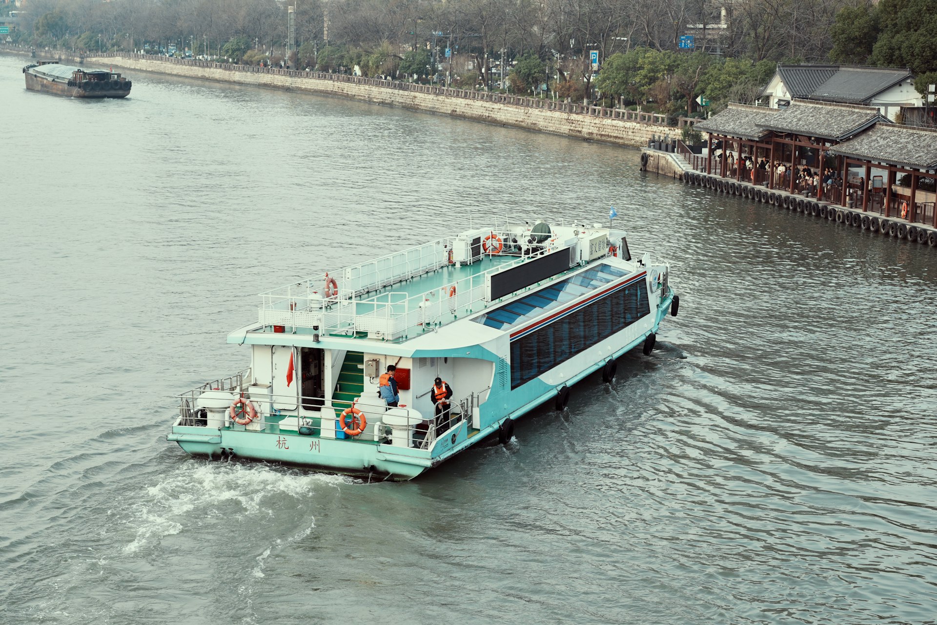 a blue and white boat traveling down a river