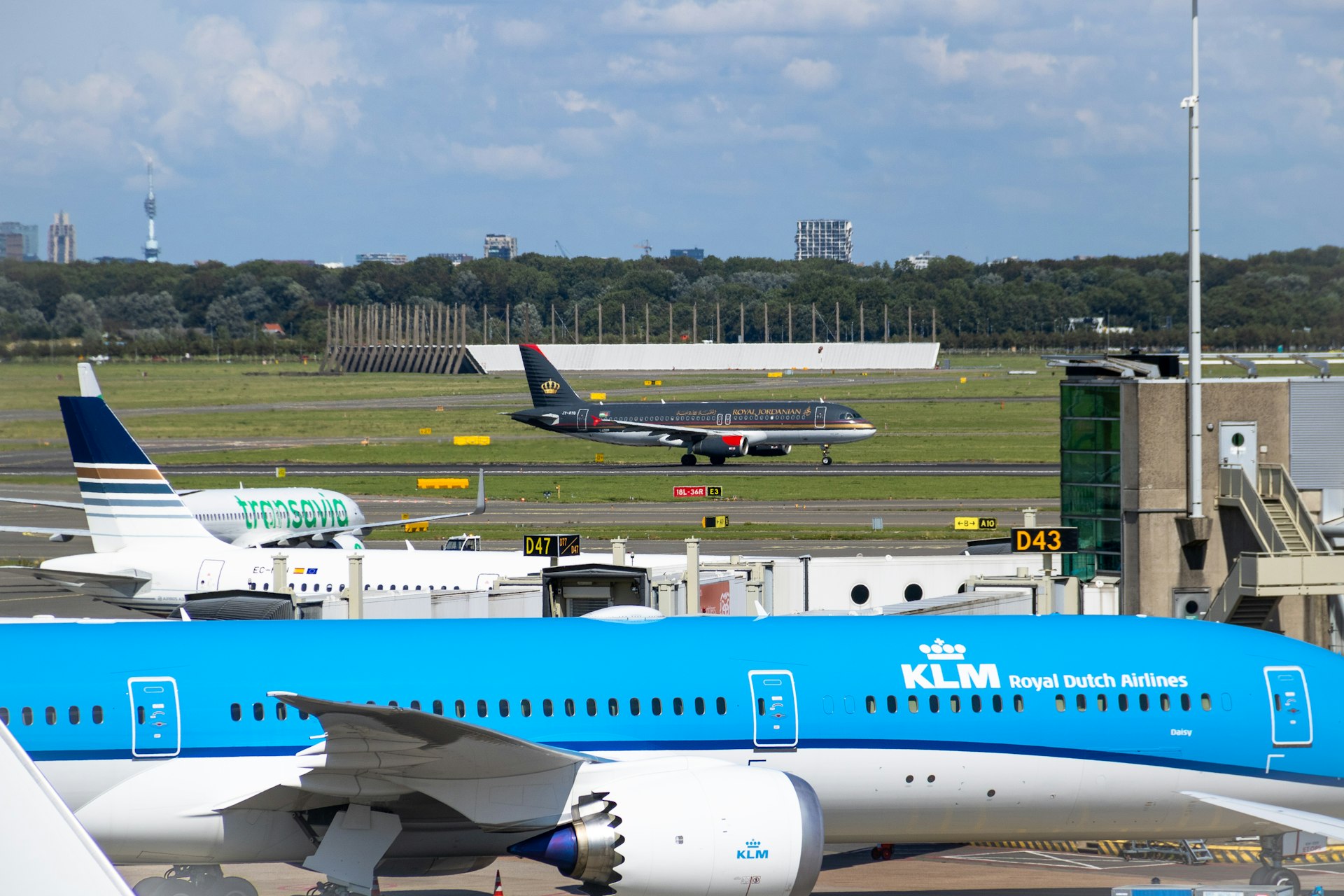 a blue and white jet airliner sitting on top of an airport tarmac
