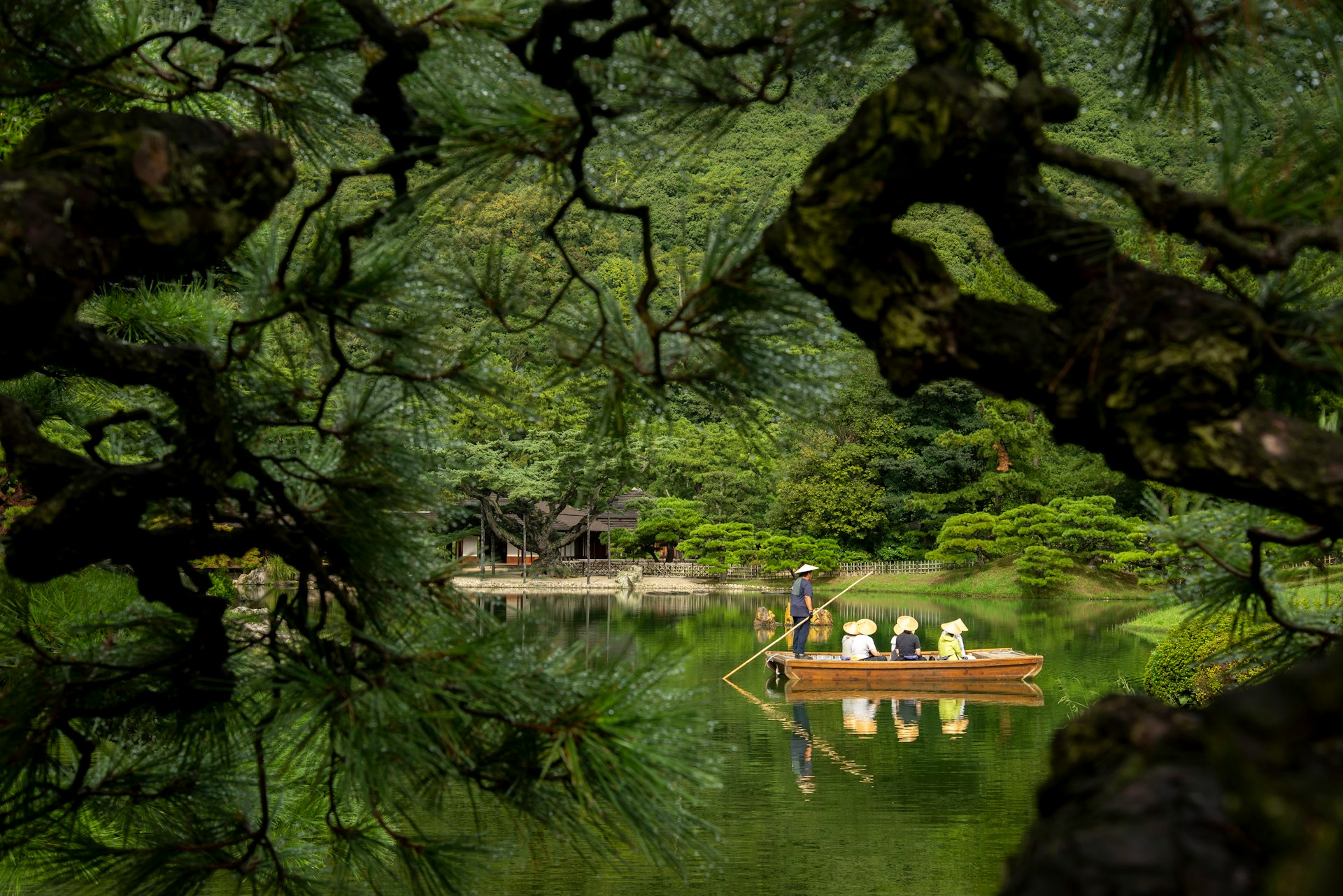 a man in a boat on a lake surrounded by trees