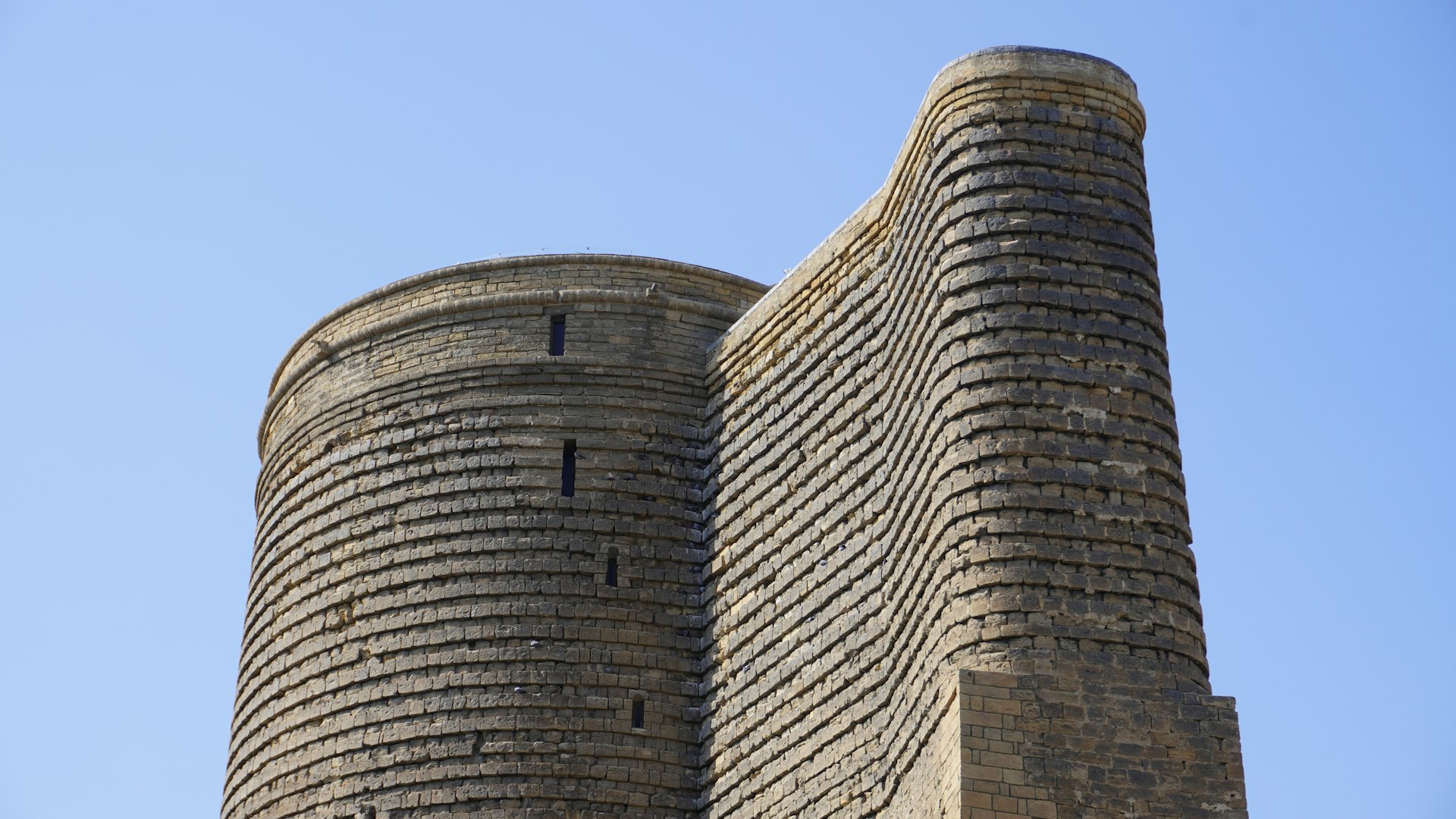The maiden tower stands tall against a blue sky.